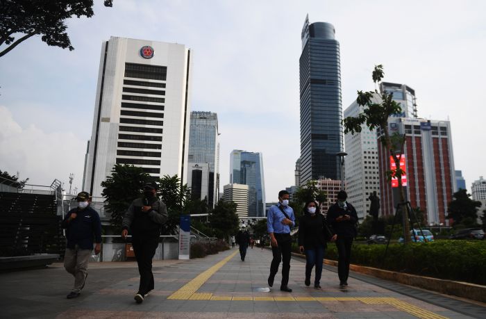 Di tengah penerapan PSBB, sejumlah pekerja berjalan di kawasan gedung perkantoran Jakarta. 