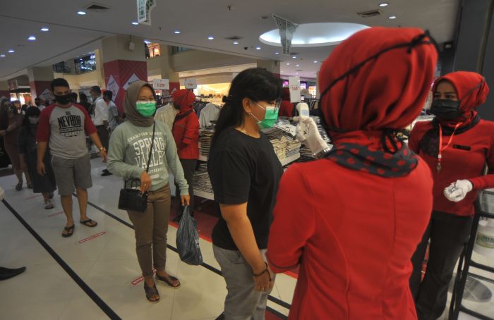 Para pengunjung  harus antri untuk pengecekan suhu dan memakai masker sebelum masuk ke mal