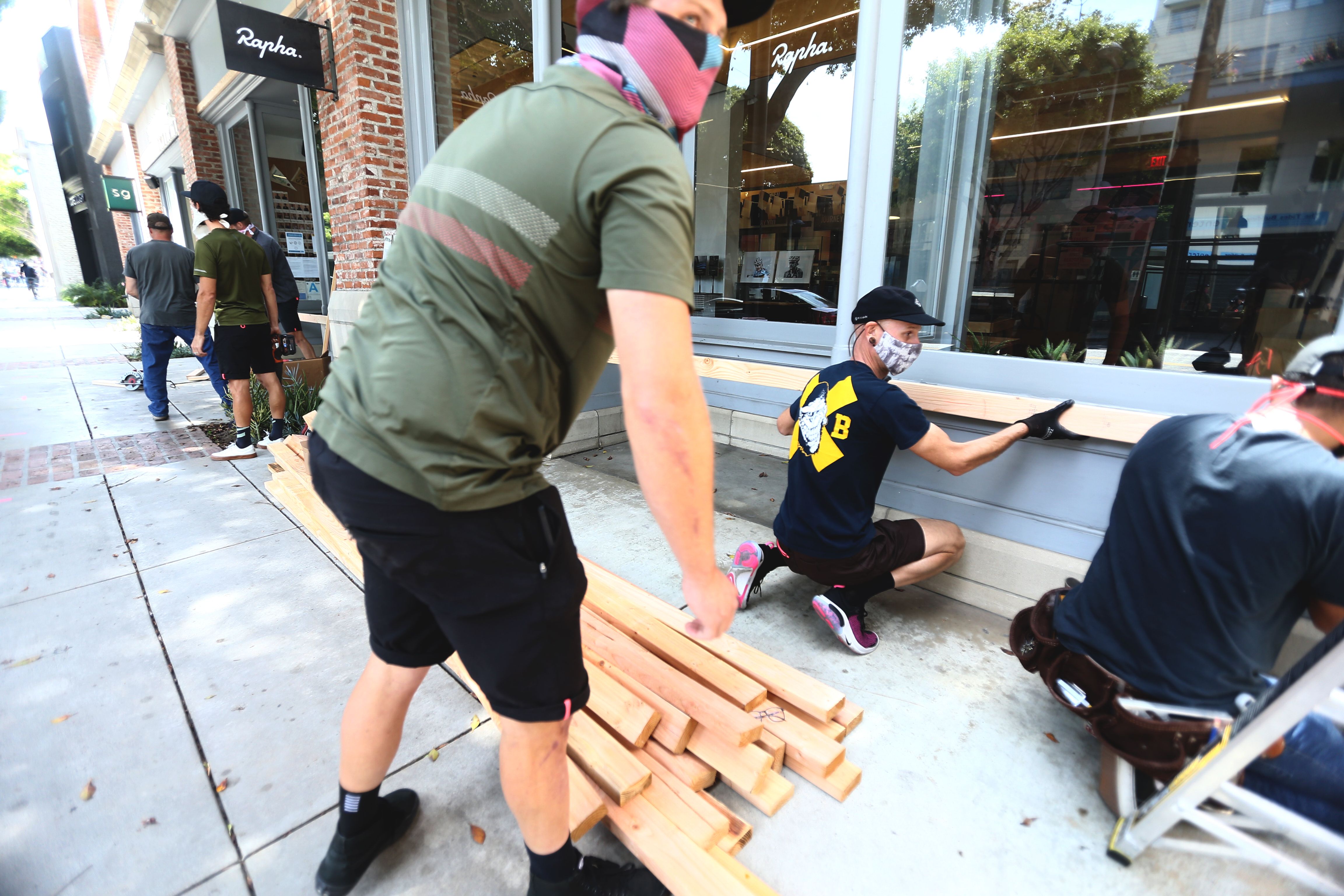  Pemilik toko mulai memasang papan di jendela etalase mereka untuk keamanan saat malam hari di Santa Monica, California, Minggu (31/5).