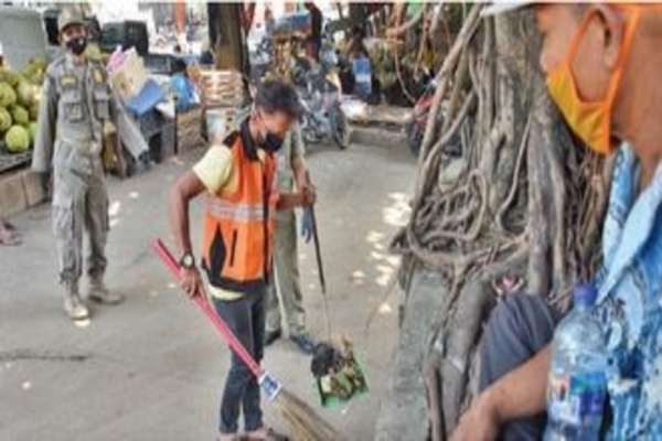 Petugas Satpol PP mengawasi warga pelanggar protokol kesehatan di Pasar Induk Kramat Jati, kemarin.