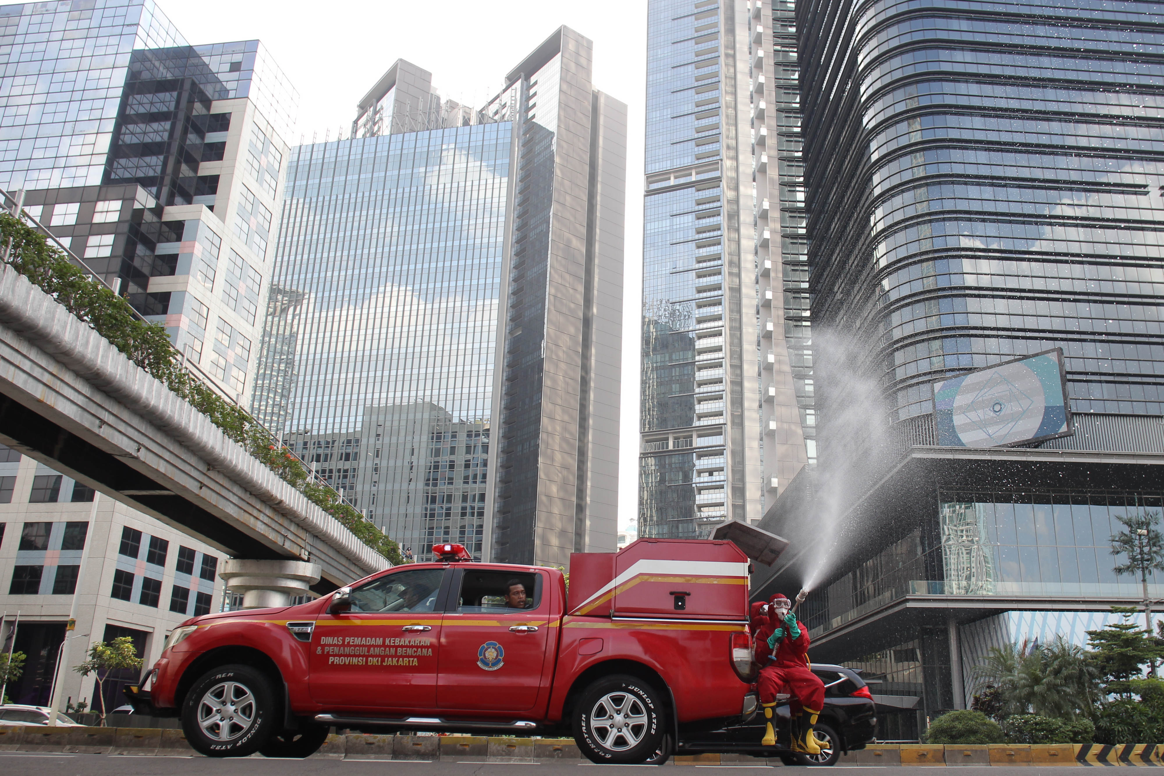 Petugas menyemprotkan cairan disinfektan di kawasan Sudirman jelang CFD.