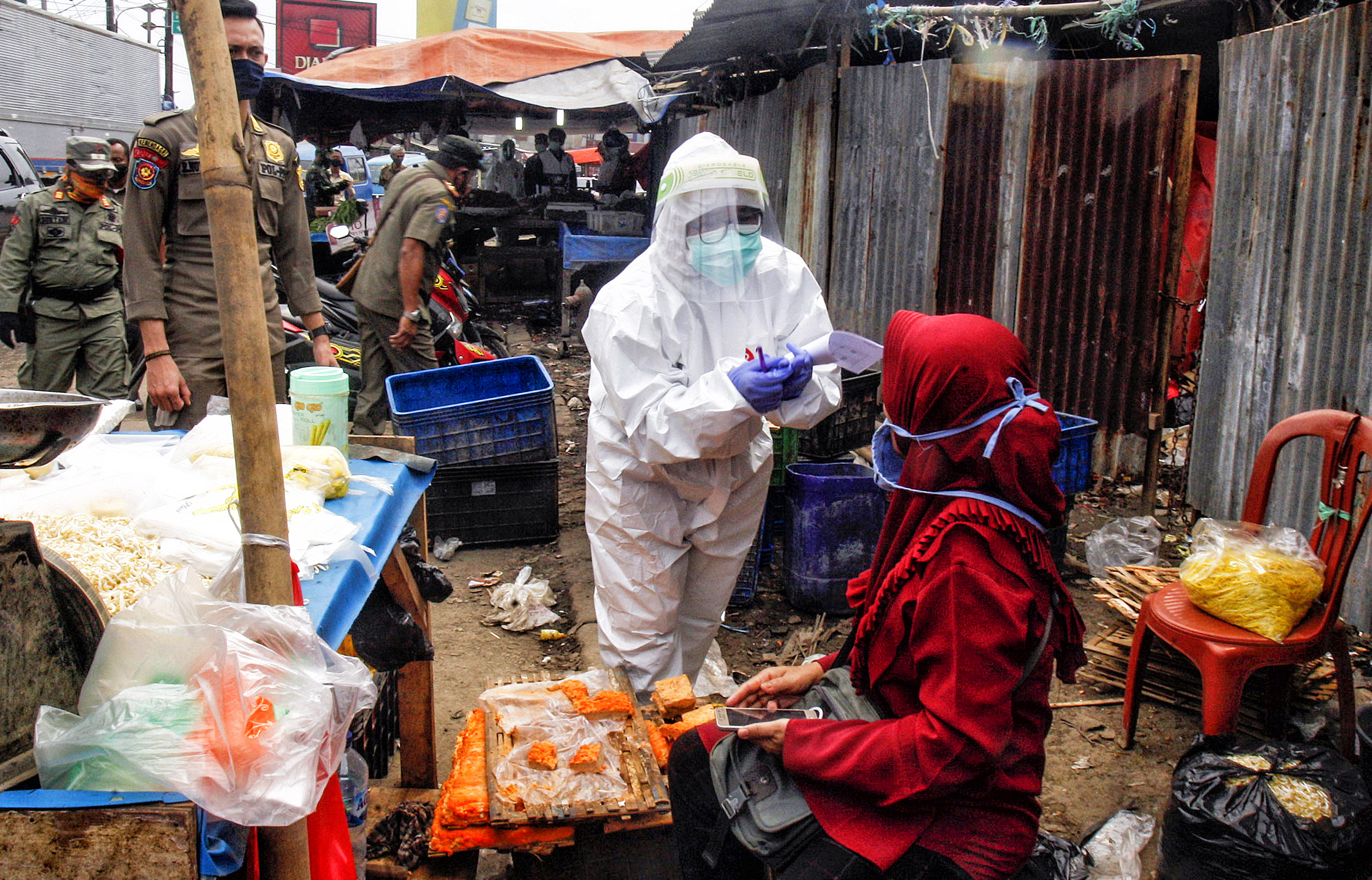 Petugas dengan APD lengkap melakukan tes diagnosa cepat (rapid test) pedagang pasar di Pasar Cileungsi, Kabupaten Bogor, Jabar, Selasa (16/6