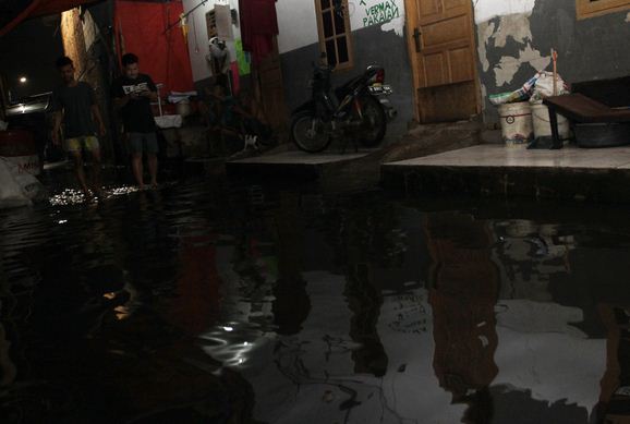Dua warga Cengkareng Timur sedang berjalan pada Jumat (25/1). Kawasan itu memiliki RW yang masuk zona merah covid-19. 