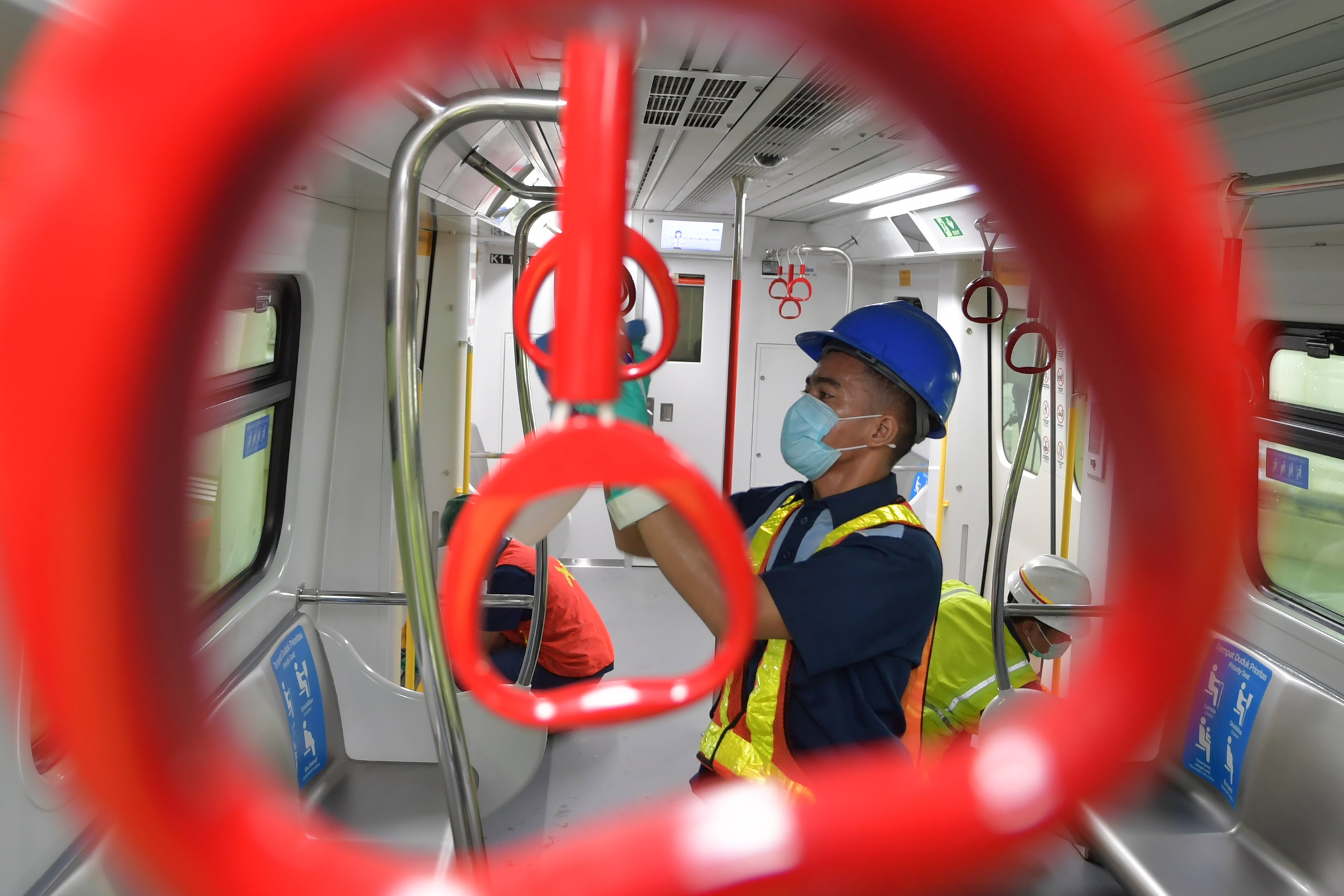  Petugas membersihkan pegangan tangan (hand grip) di Depo LRT Jakarta
