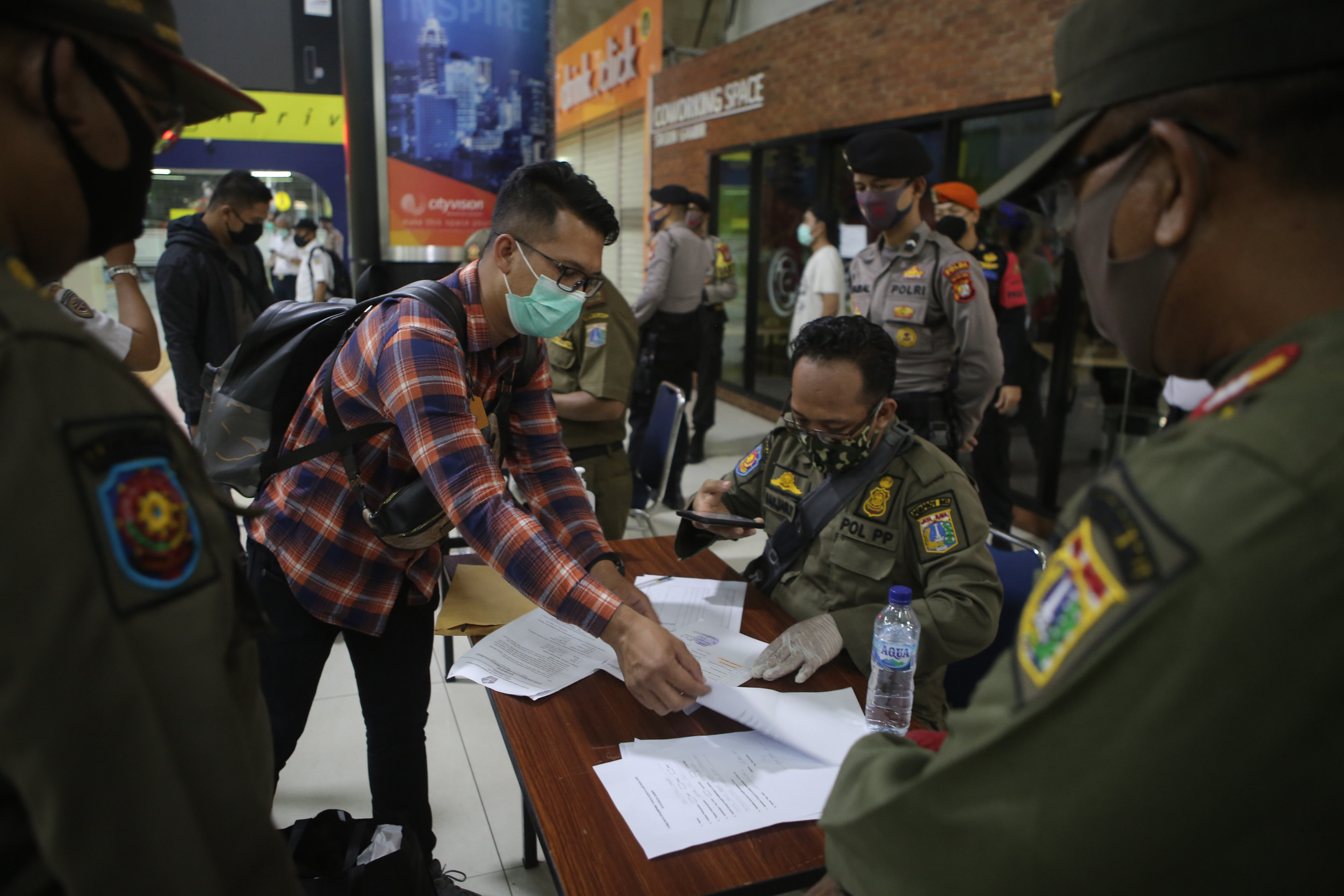 Penumpang yang baru tiba di stasiun Gambir Jakarta menunjukkan SIKM miliknya pada petugas