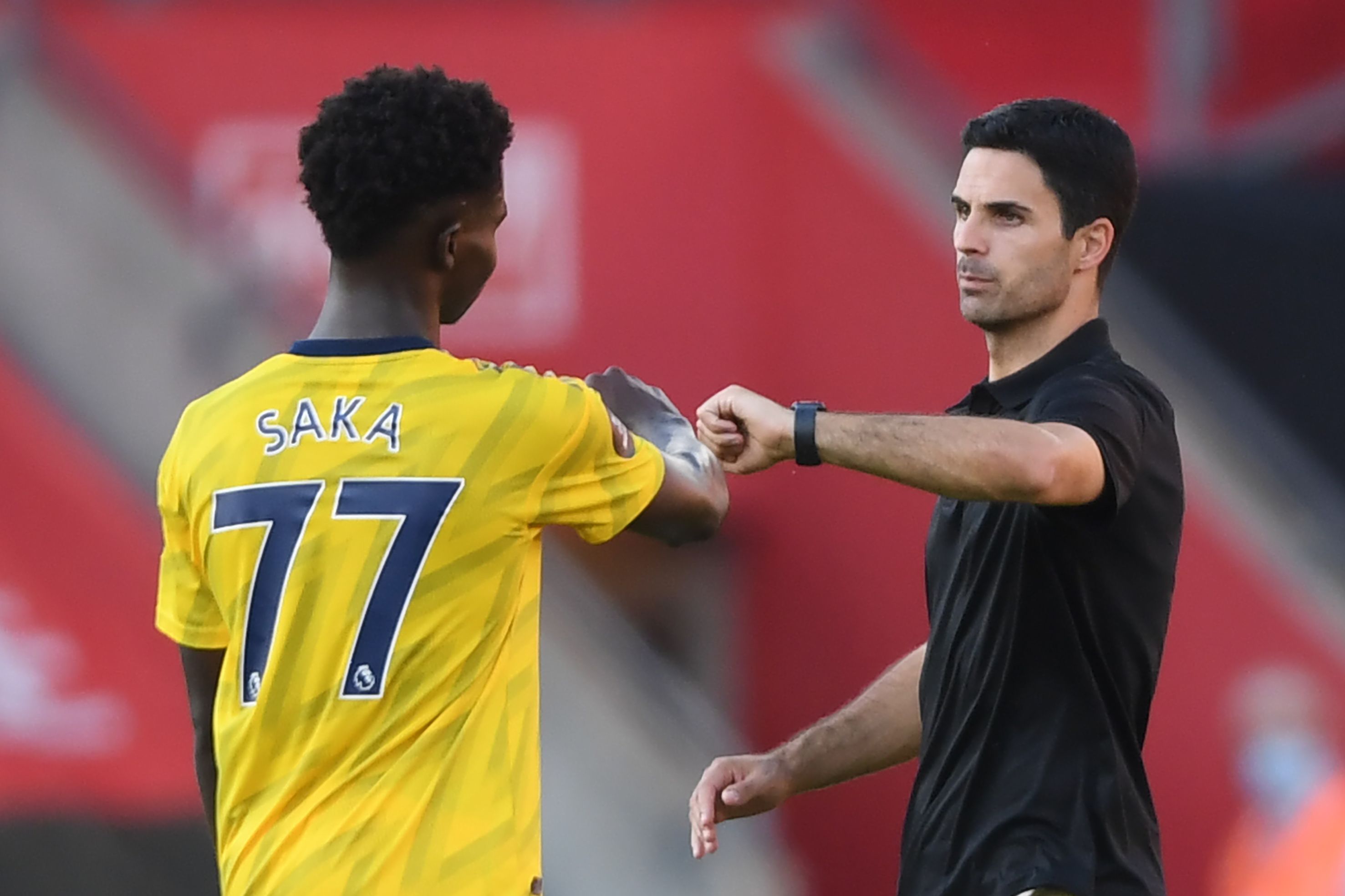 Pelatih Arsenal Mikel Arteta (kanan) melakukan tos dengan  pemain striker Bukayo Saka saat laga melawan Southampton, Jumat (26/6). 