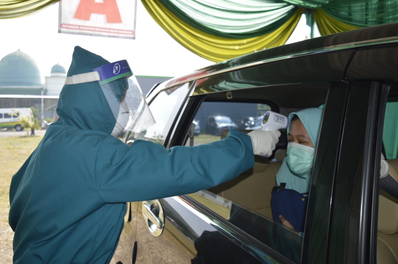 Petugas Pondok Pesantren Bumi Shalawat memeriksa kesehatan santri di dalam mobil sebelum masuk ponpes, Jumat (26/6/2020)