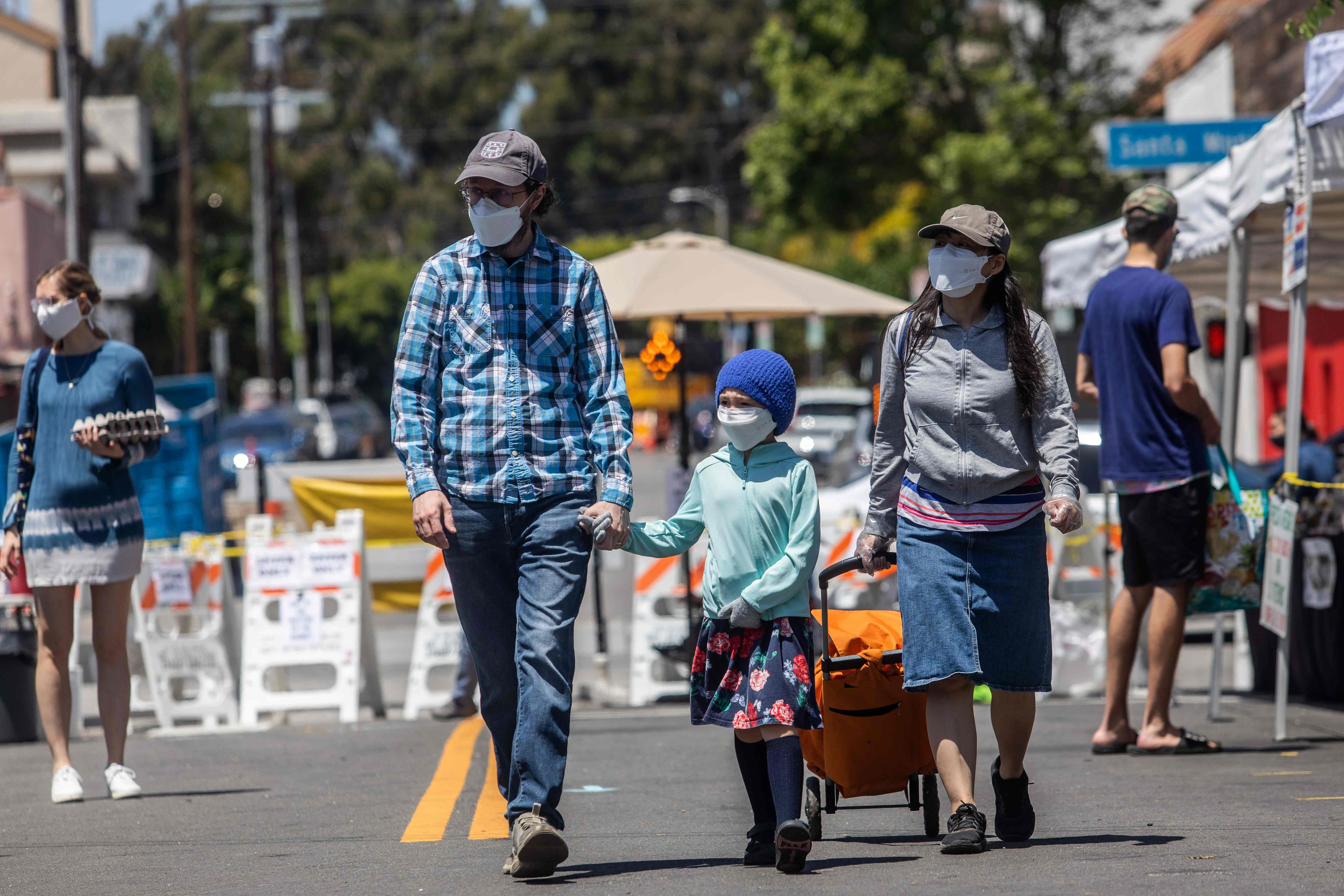 Sebuah keluarga mengenakan masker wajah di Santa Monica, California.