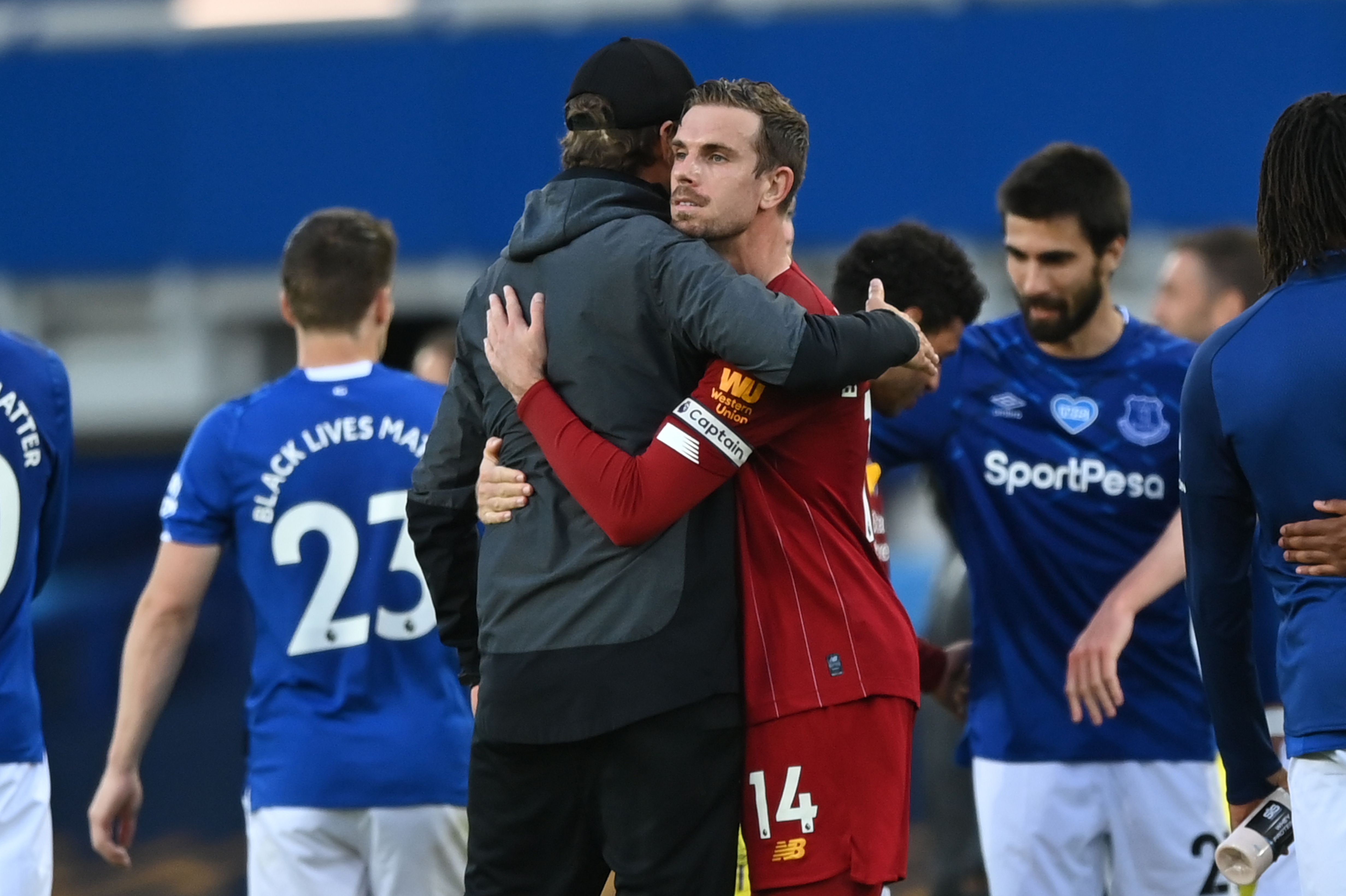 Pelatih Liverpool Jurgen Klopp dan Jordan Henderson berpelukan usai laga melawan Everton di Goodison Park, Senin (22/9).