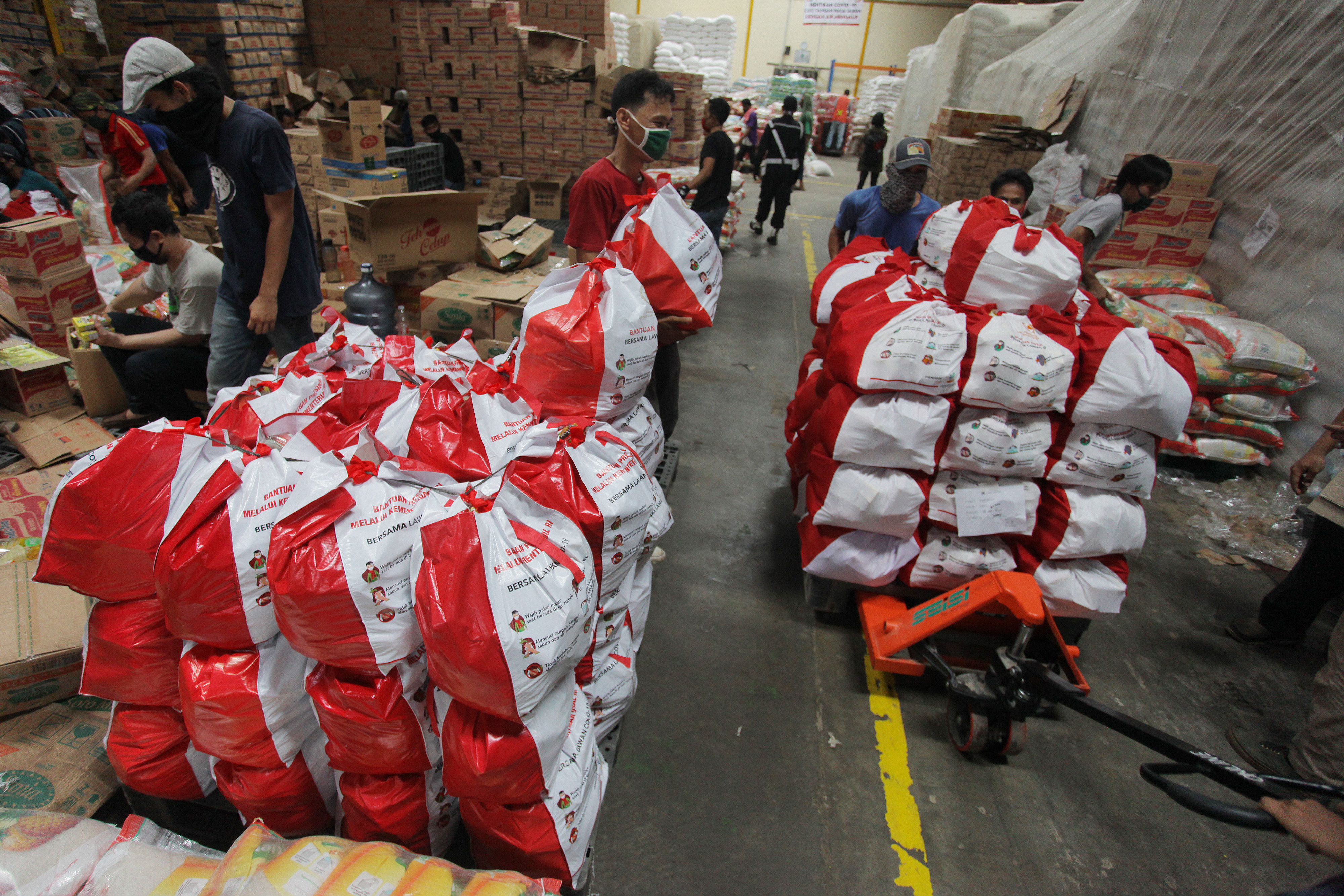 Pekerja beraktivitas di gudang Food Station, Cipinang, Jakarta, Senin (18/5) melakukan pengemasan bantuan sosial untuk masyarakat.