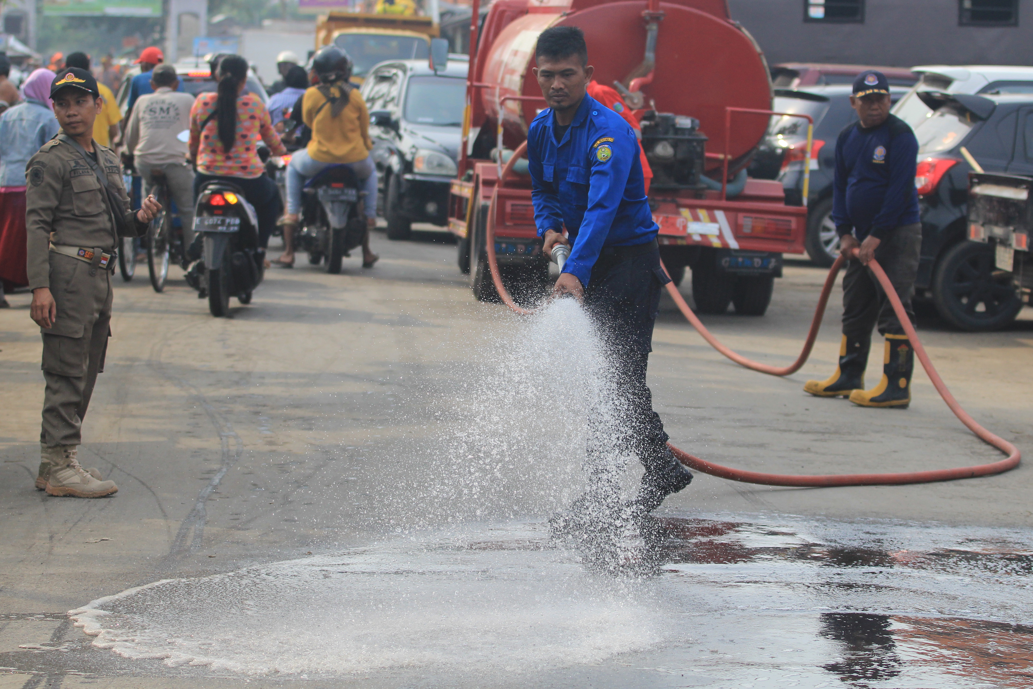Petugas menyemprotkan air ke jalan saat kegiatan sosialisasi dan kebersihan di Pasar Baru, Indramayu, Jawa Barat, beberapa waktu lalu.
