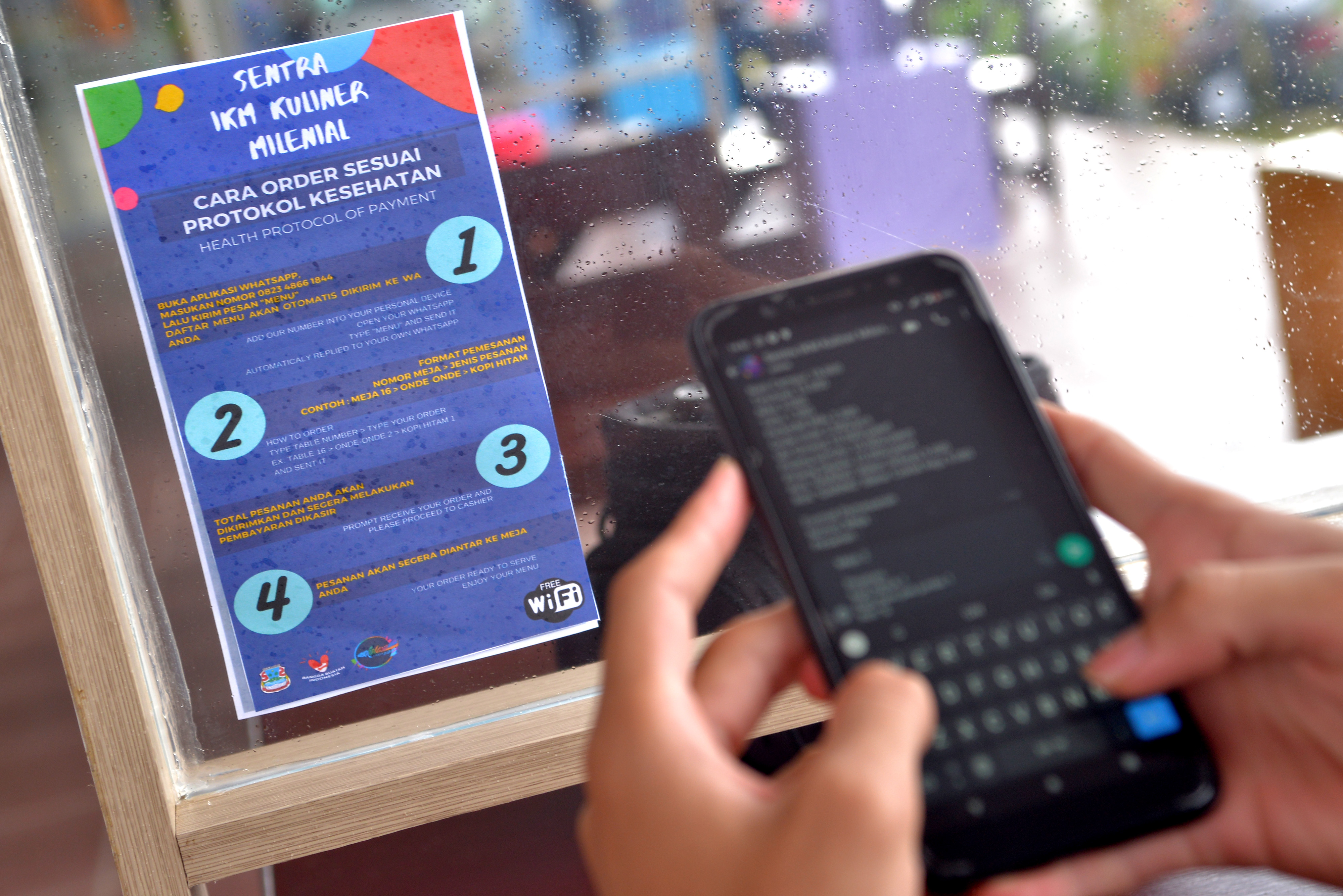 Pengunjung memesan menu menggunakan telepon genggamnya di salah satu warung kopi di Manado, Sulawesi Utara, Selasa (9/6). 