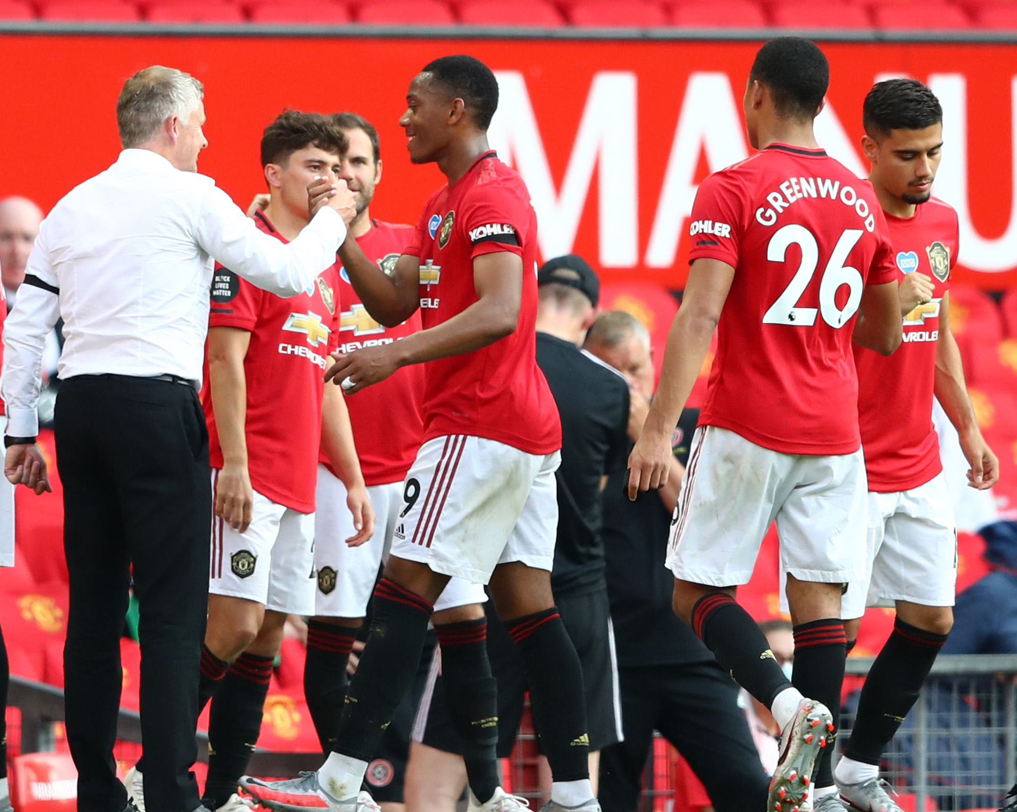 Pelatih Mancheter United Ole Gunnar Solskjaer (kiri) bersalaman dengan Anthony Martial usai laga melawan Sheffield United, Kamis (26/6).    