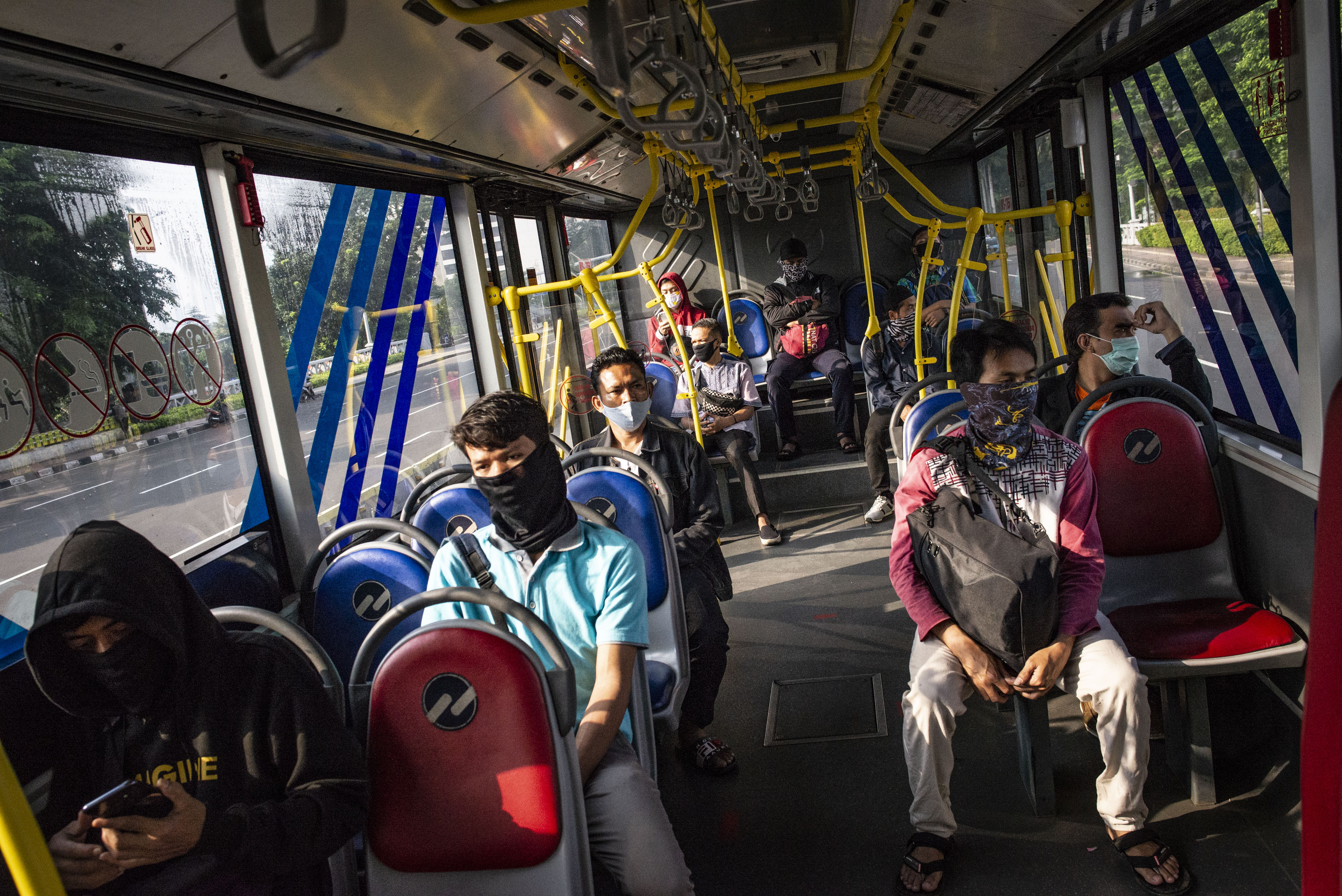 Penumpang Transjakarta mengenakan masker untuk mencegah penularan covid-19.