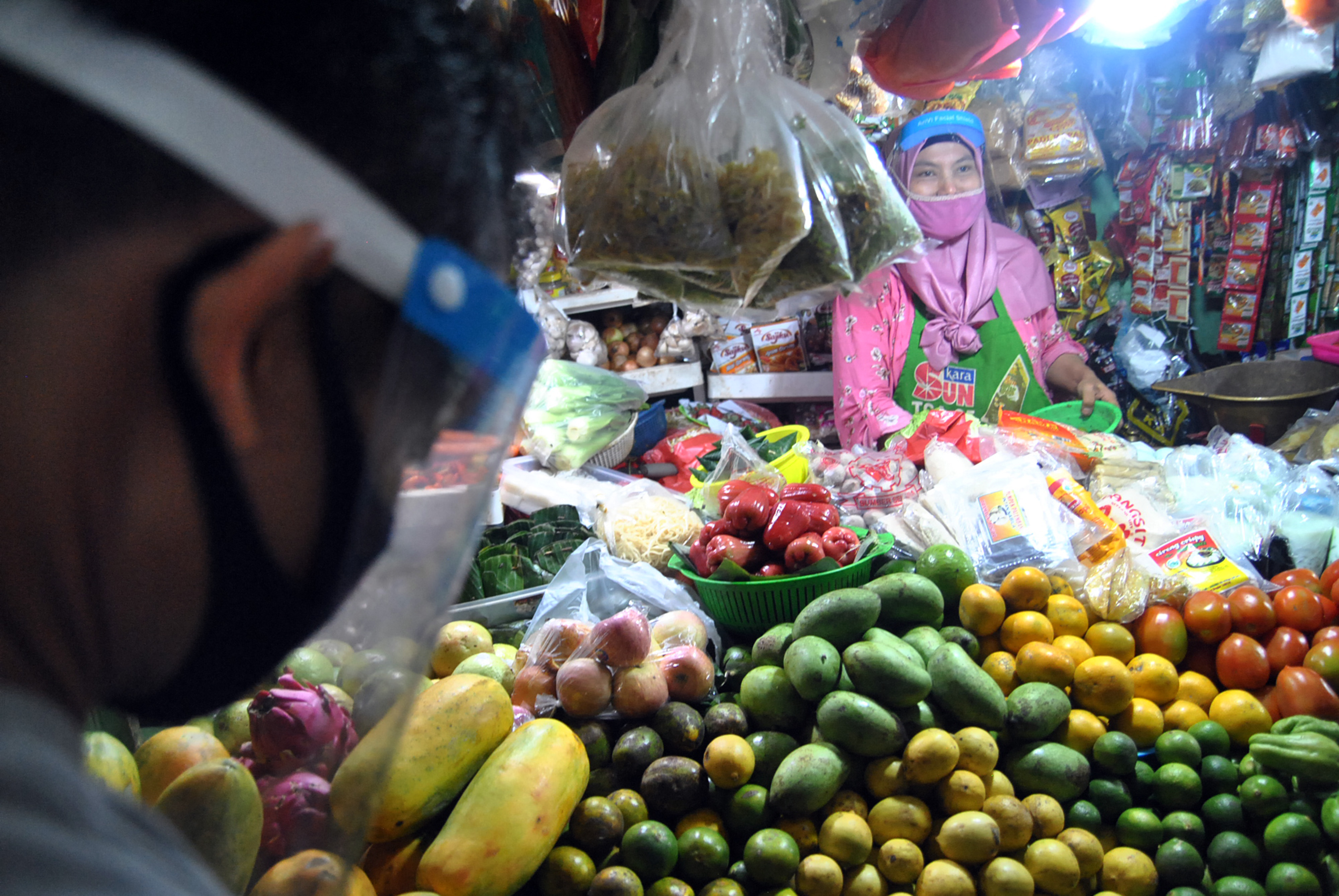 Pedagang di Pasar Sukasari, Bogor, menggunakan face shield untuk menghindari penularan covid-19.