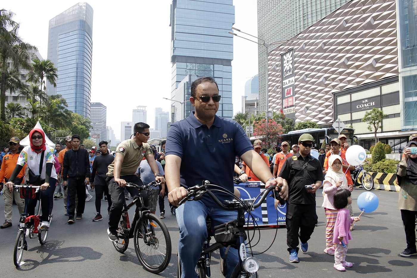 Gubernur DKI Jakarta Anies Baswedan (tengah bersepeda) menyapa dan berfoto dengan warga saat CFD.