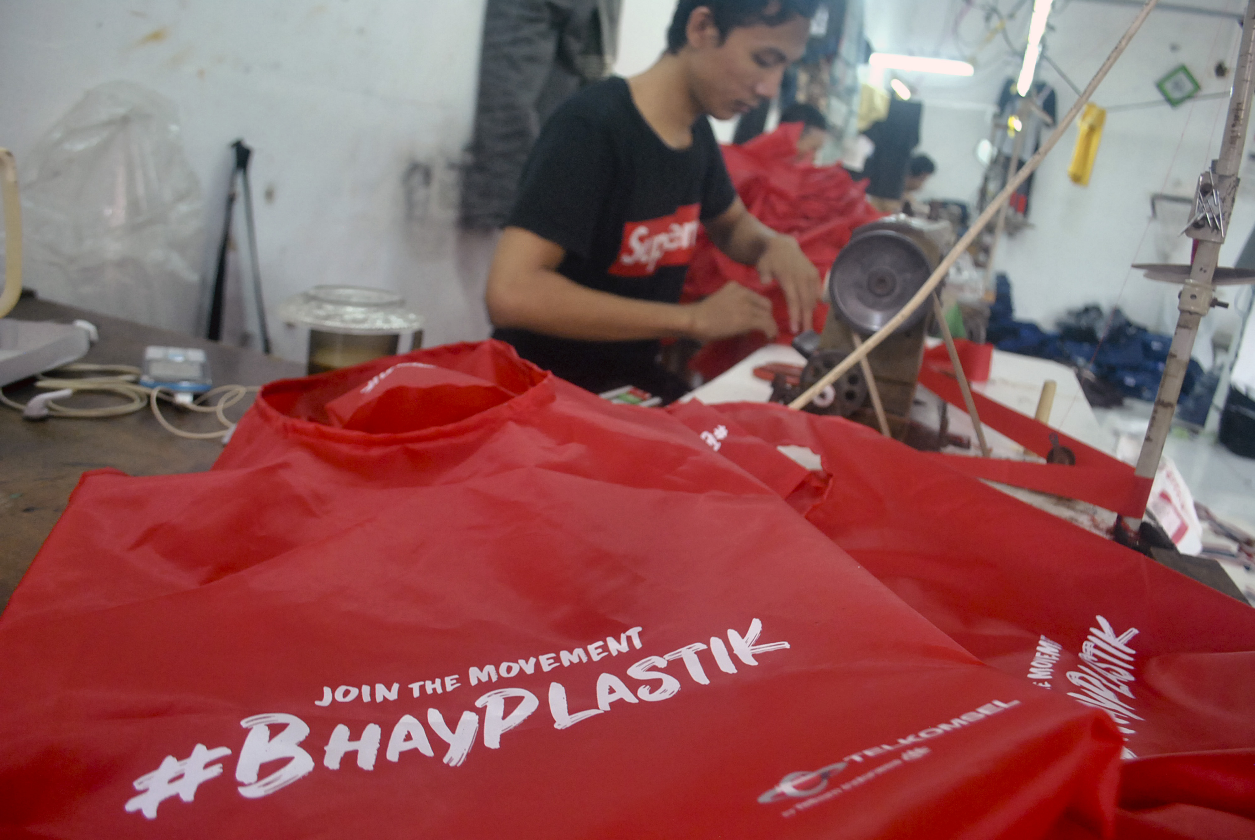 Pekerja memproduksi tas belanja berbahan parasut pengganti kantong plastik