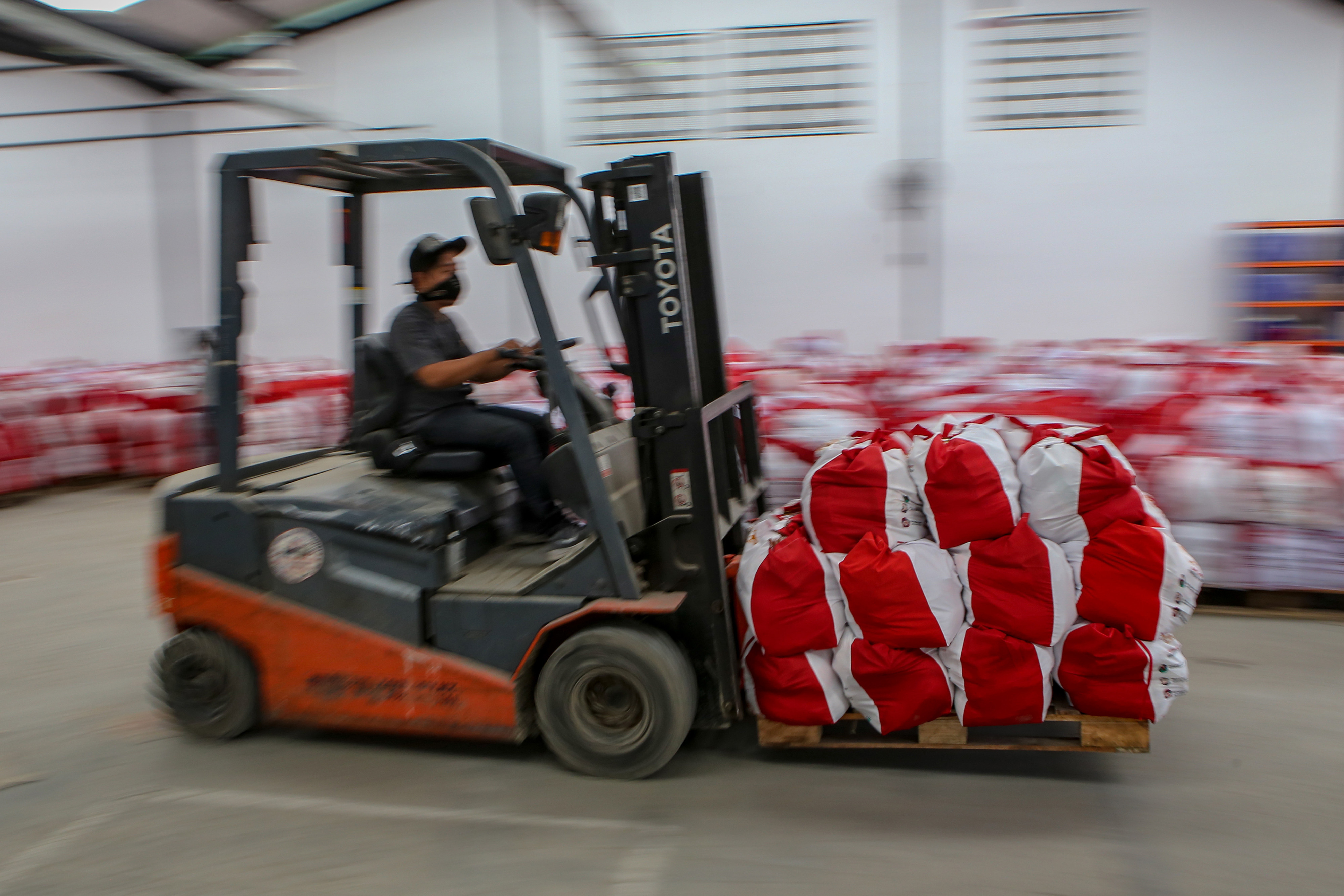 Pekerja mengangkut bantuan paket sembako dari Presiden di Goodang.com, Neglasari, Kota Tangerang, Banten, Sabtu (9/5).