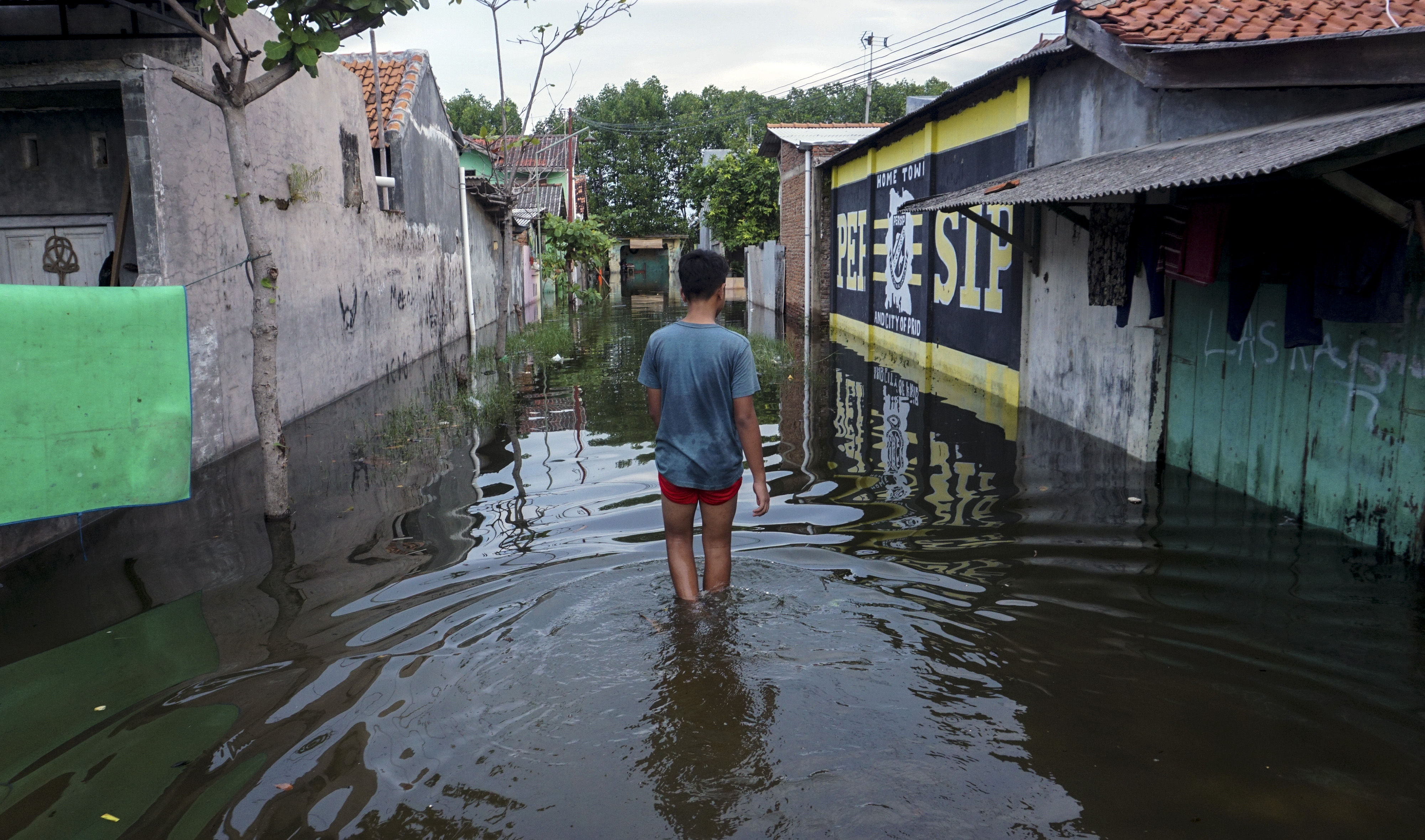  Warga berjalan melewati banjir rob di Slamaran, Pekalongan, Jawa Tengah, Senin (1/6/2020)