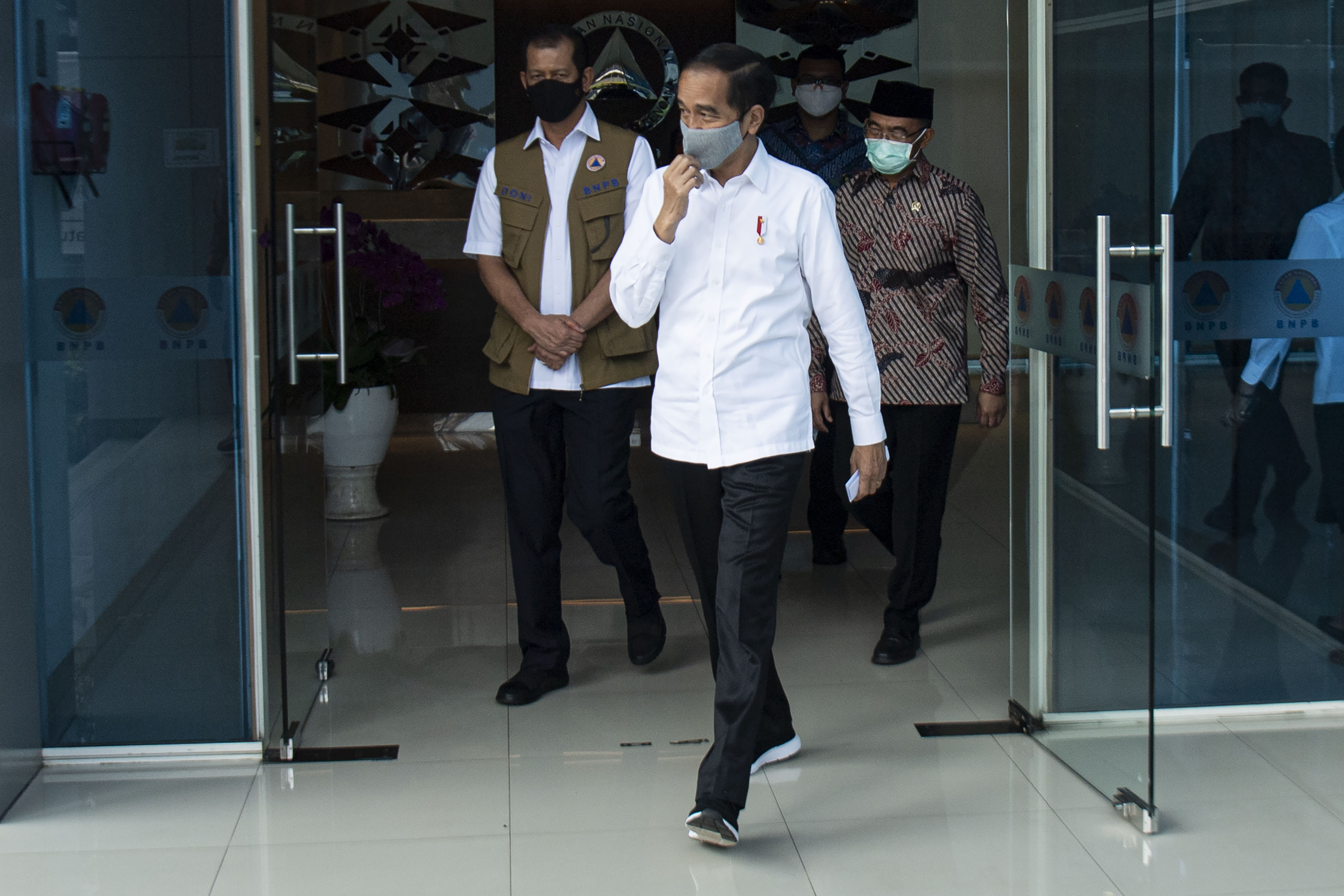 Presiden Joko Widodo (tengah) berjalan didampingi Ketua Gugus Tugas Nasional COVID-19 Letjen TNI Doni Monardo (kiri)