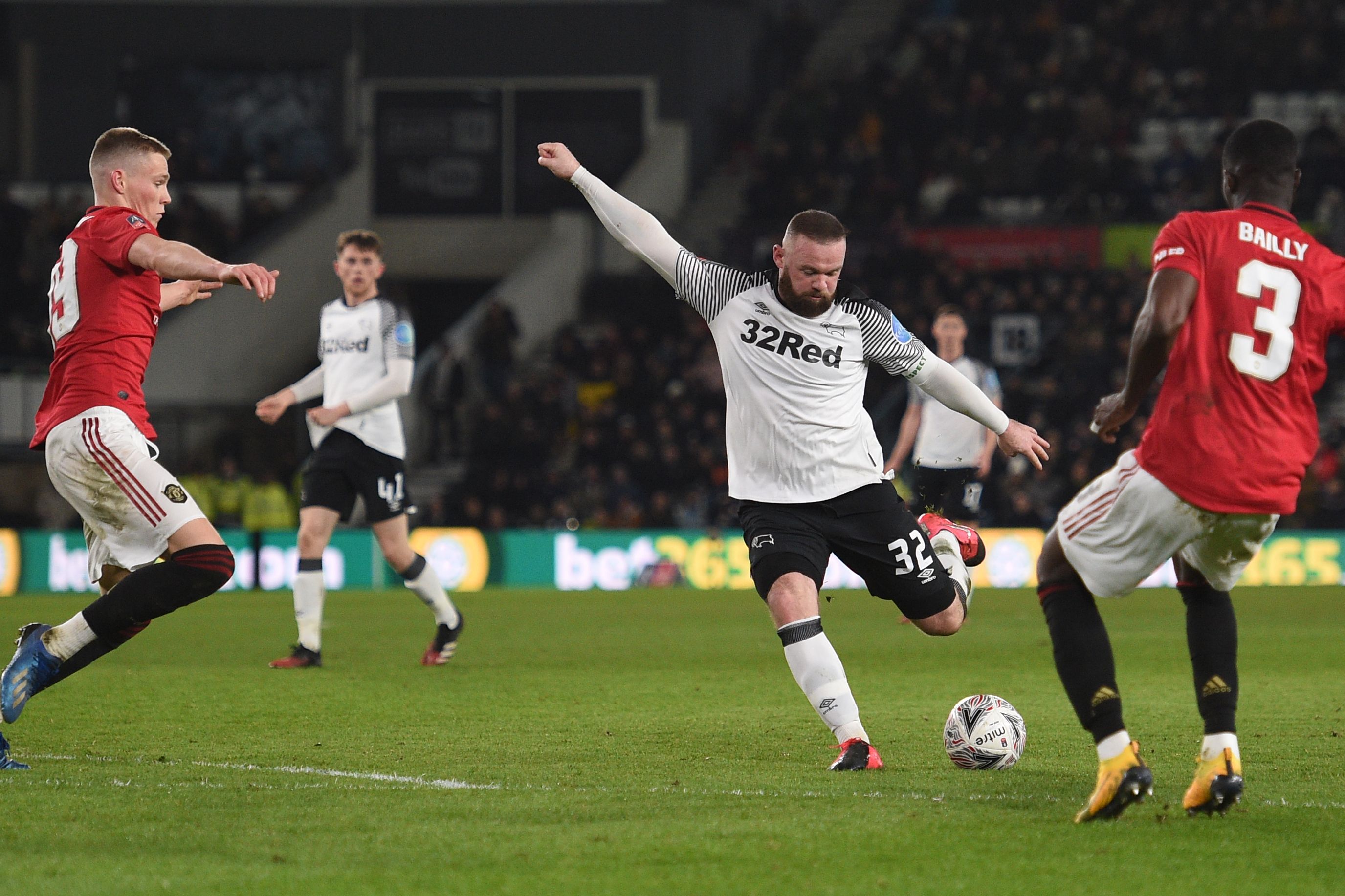 Striker Derby County, Wayne Rooney, menendang bola dalam pertandingan Piala FA Inggris.