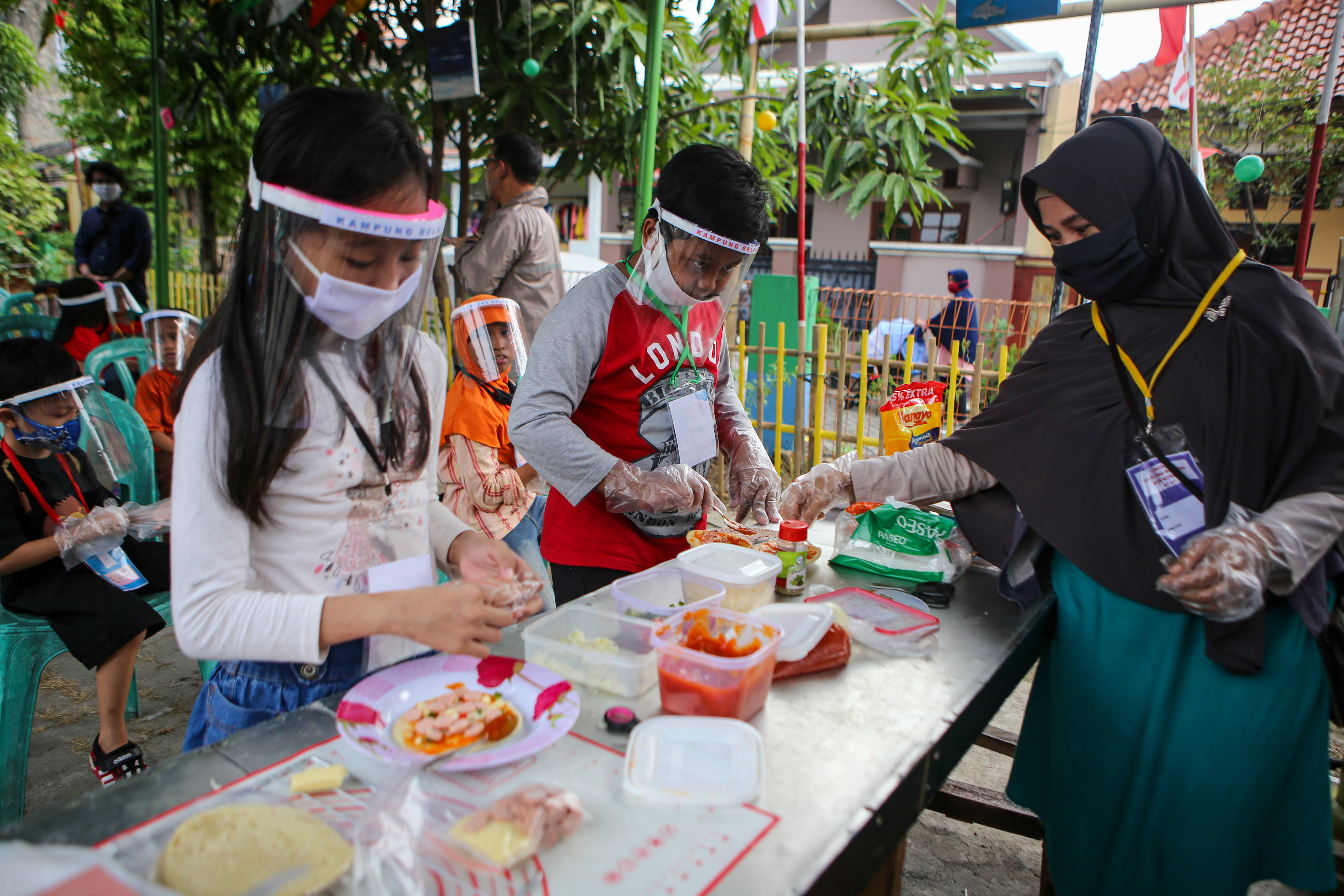 Ilustrasi anak-anak belajar dengan menggunakan pelindung wajah dan masker. 