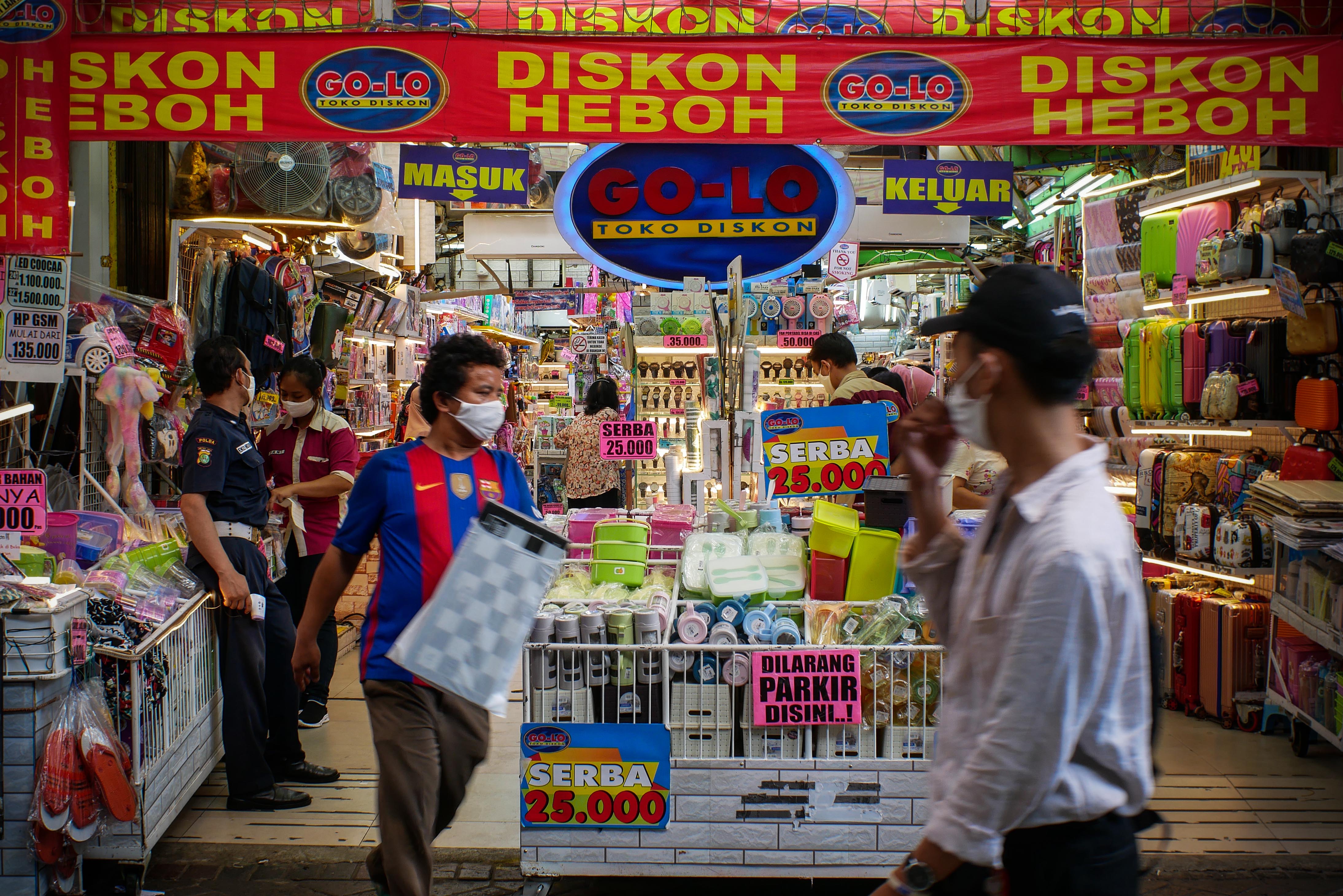 Pengunjung melintasi salah satu toko di Pasar Baru, Jakarta, Senin (8/6/2020).