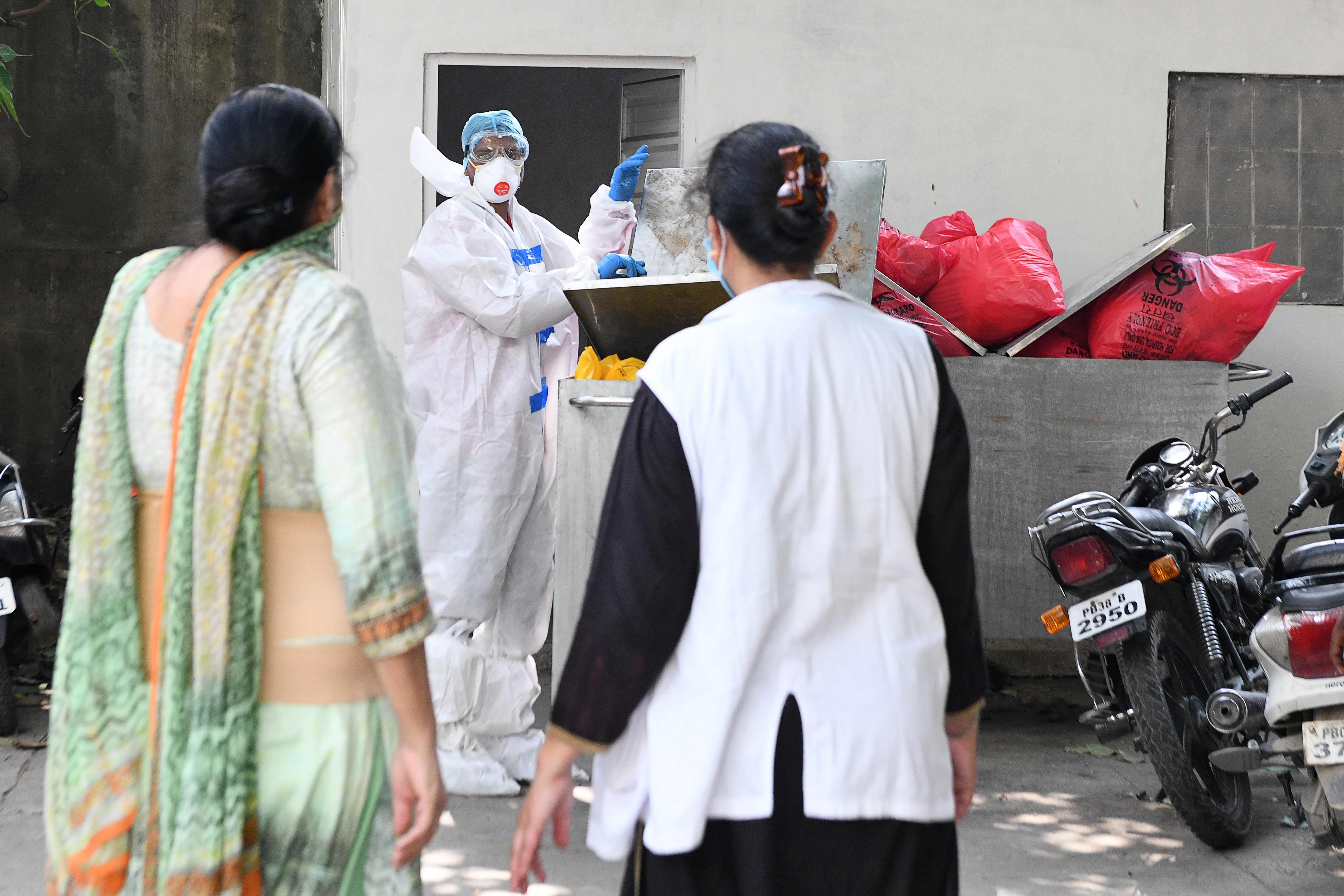 Petugas kebersihan membuang sampah limbah medis dari pasien covid-19  di RS Guru Nanak Dev, Amritsar (12/6/2020)