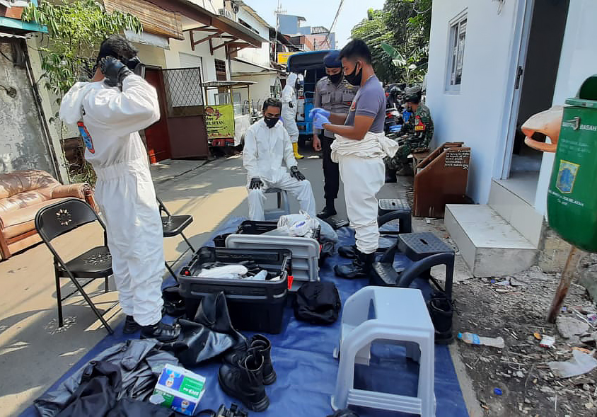  Para personel Brimob bersiap mengenakan pakaian Hazmat saat akan melakukan penyemprotan disinfektan di Kelurahan Sawah Besar, Jakarta Pusat