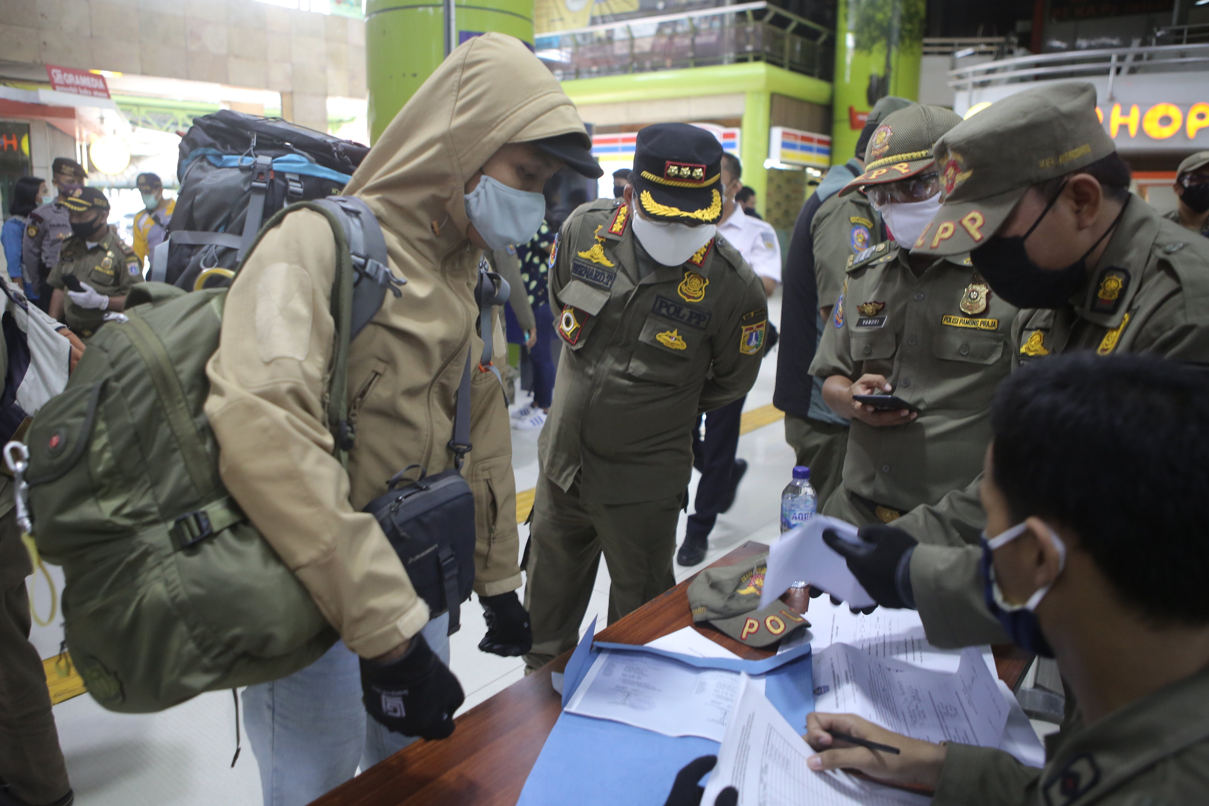 Pemeriksaan Surat Izin Keluar Masuk bagi penumpang yang tiba di Stasiun Gambir Jakarta oleh petugas gabungan