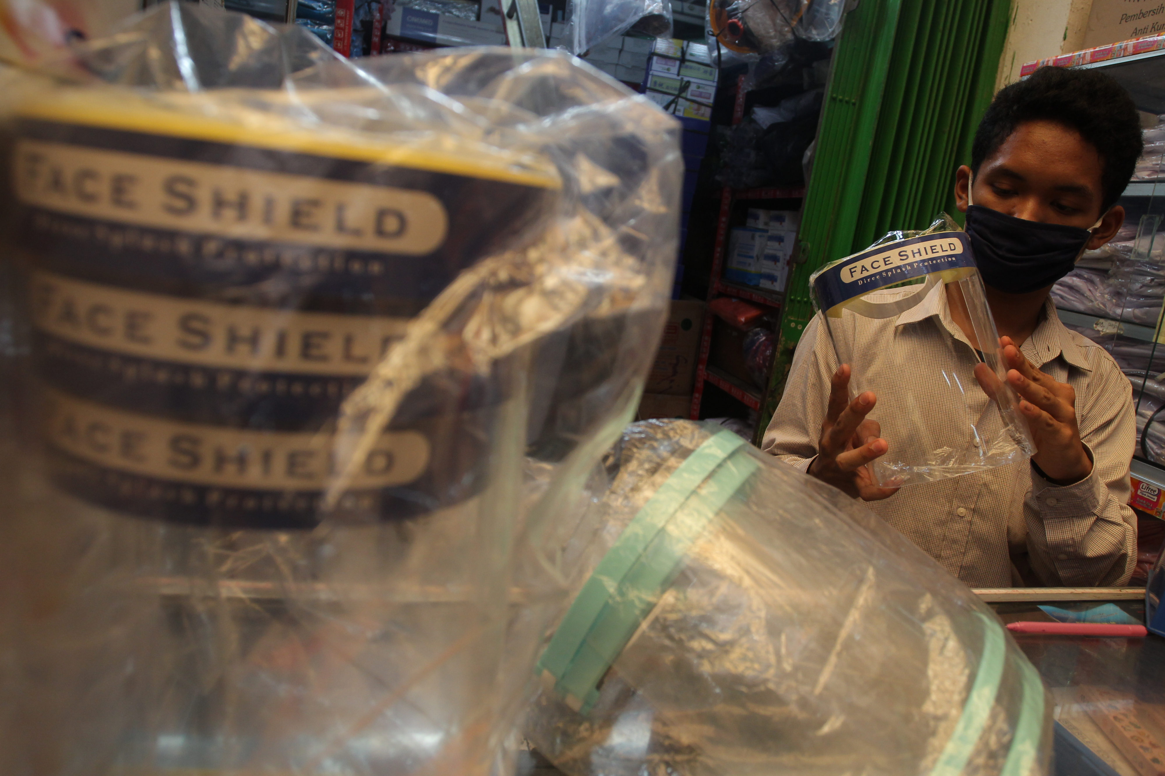 Pedagang menata barang dagangngan pelindung wajah (face shield) di Pasar Pramuka, Jakarta, Sabtu (6/6).