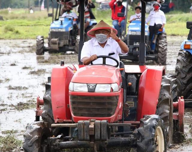 Gubernur Sulut Olly Dondokambey naik traktor gilas lahan agar siap ditanami.