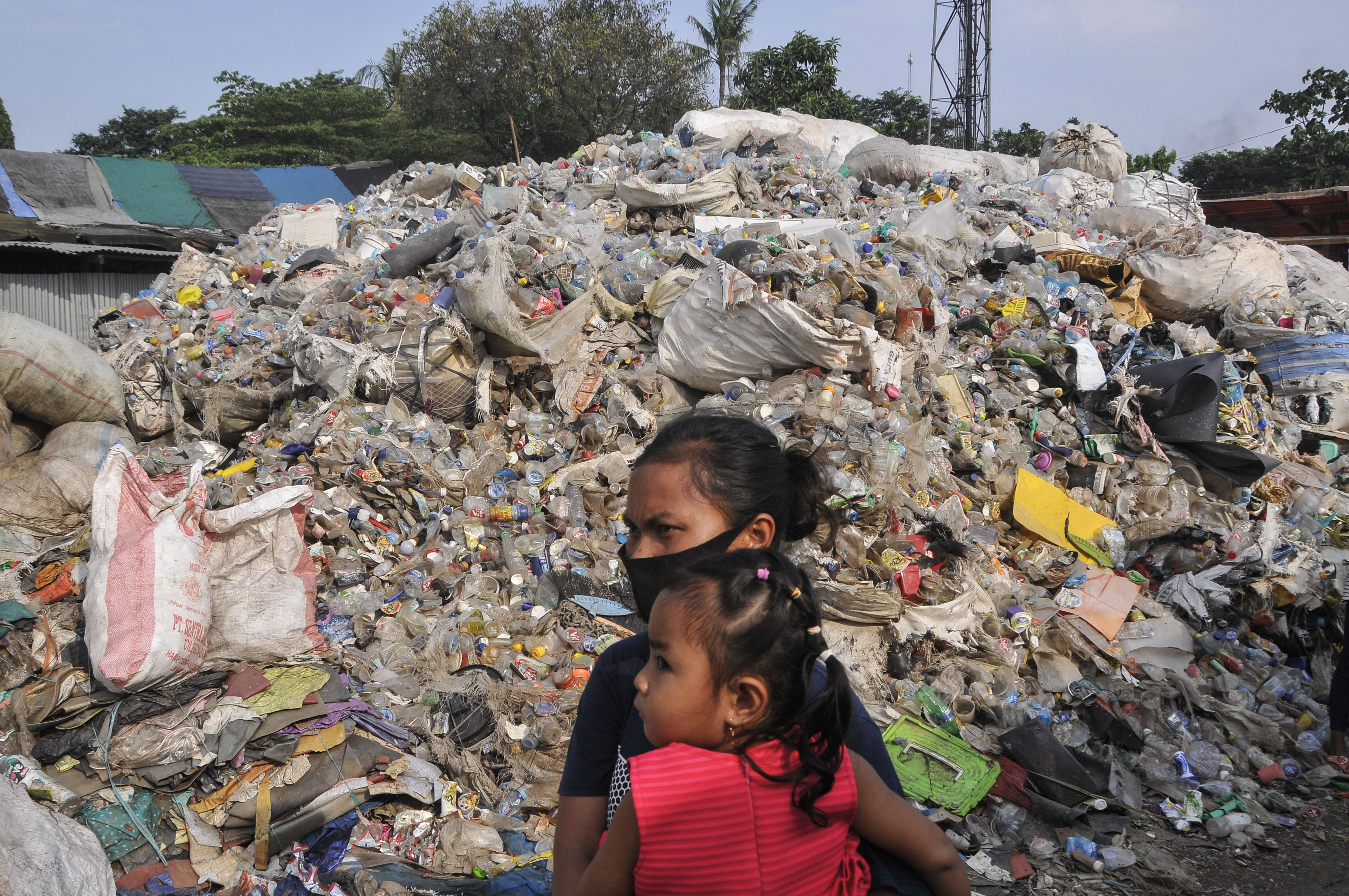 Warga melintas di samping limbah sampah plastik Bantargebang, Bekasi, Jawa Barat, Jum'at (5/6/2020)