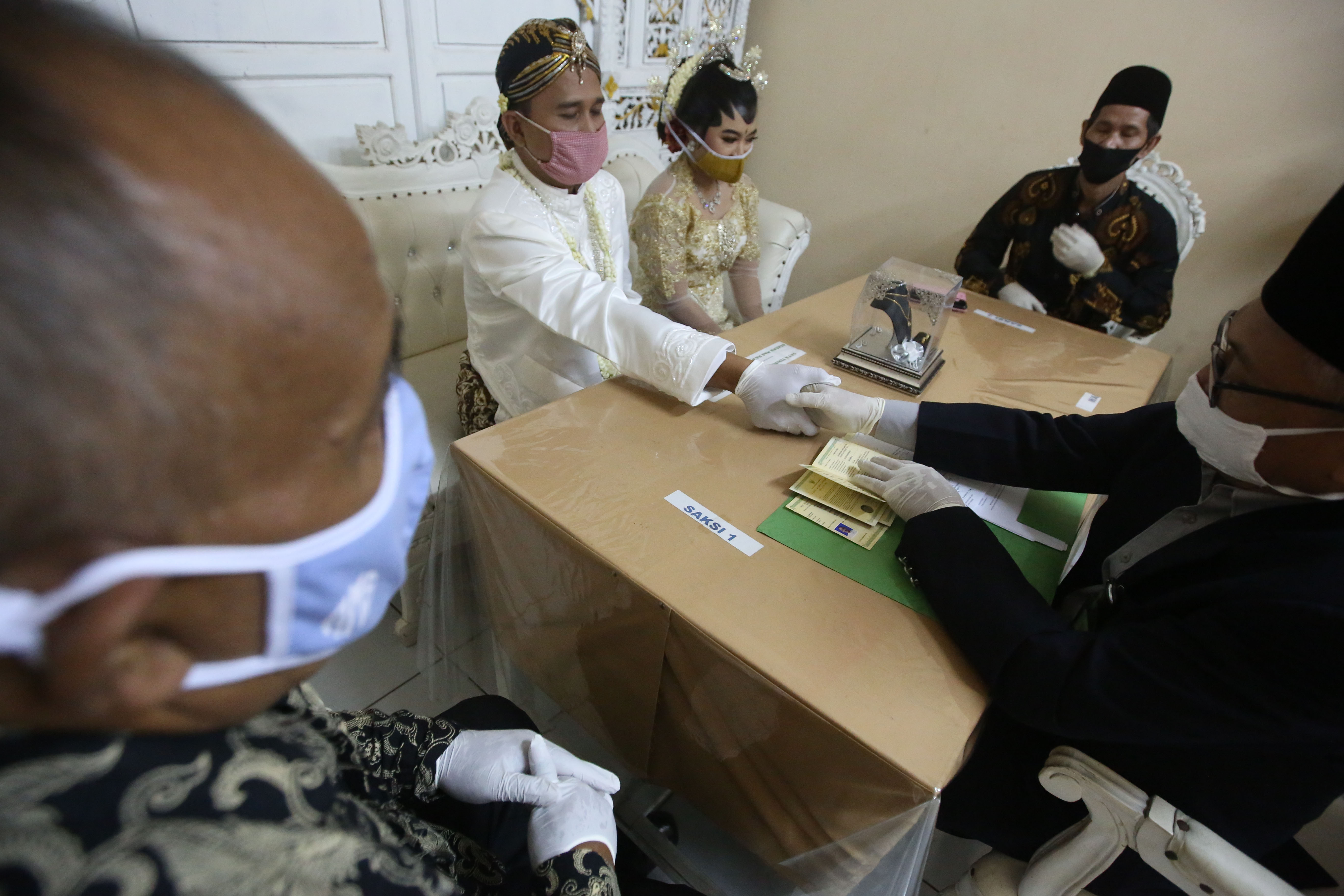 Pasangan melangsungkan akad nikah dengan prokol kesehatan PSBB transisi DKI Jakarta di Kantor Urusan Agama, Grogol Petamburan, Jakarta Barat