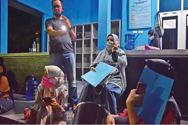 Sejumlah warga bertahan hingga malam di halaman SMAN 8 Kota Pekanbaru saat memprotes dugaan kecurangan dalam penerimaan peserta didik baru 