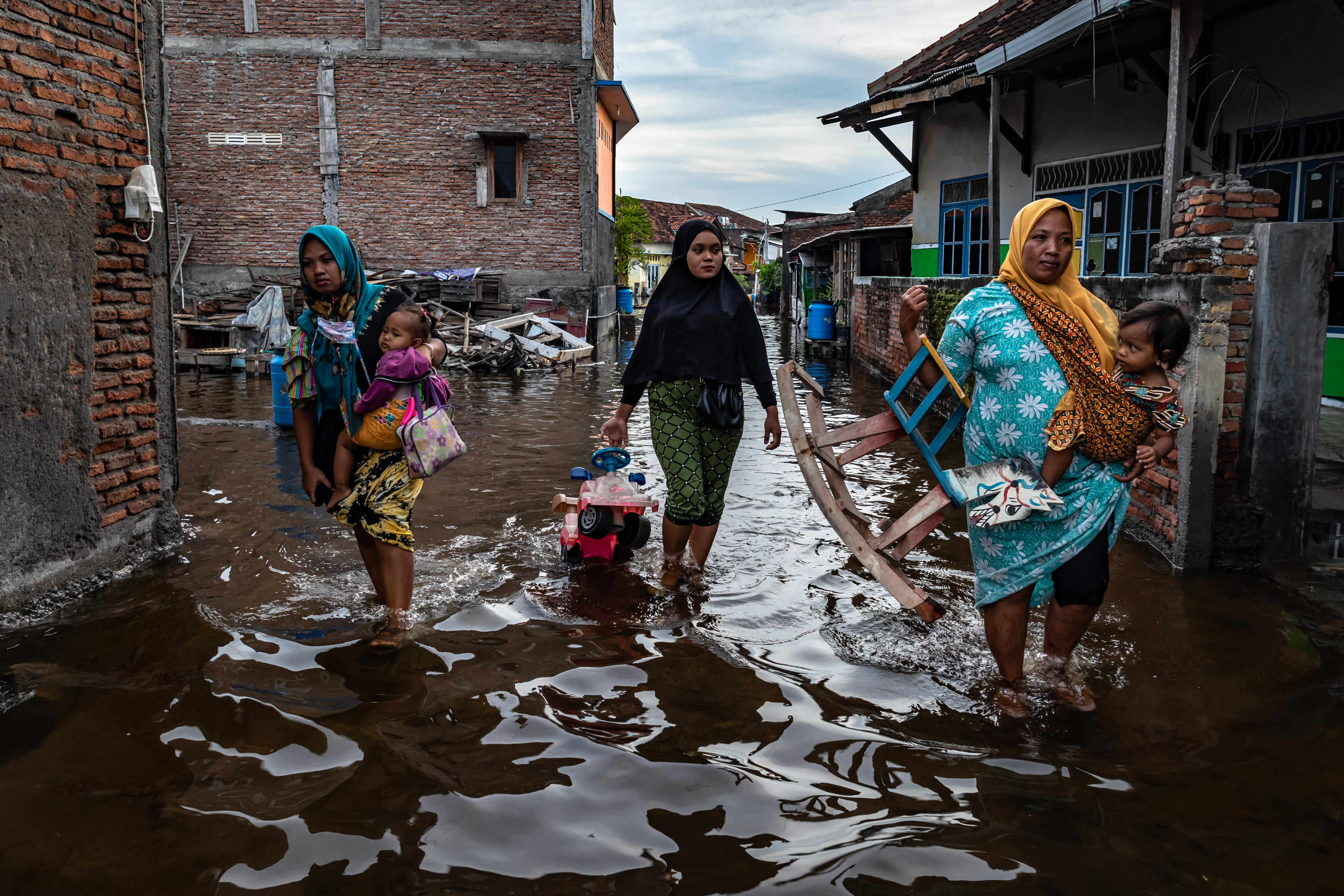 Sejumlah warga mengungsi ke tempat yang lebih tinggi agar terhindar dari banjir rob  merendam permukimandi Desa Sriwulan, Sayung, Demak.