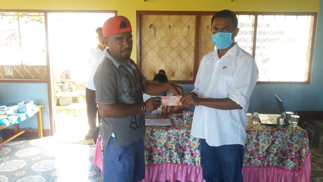 Kepala Desa  Kenere, Mikael Koliwutun Klodor menyerahka bantuan sosial tunai bersumber dari dana desa untuk warga terdampak covid-19