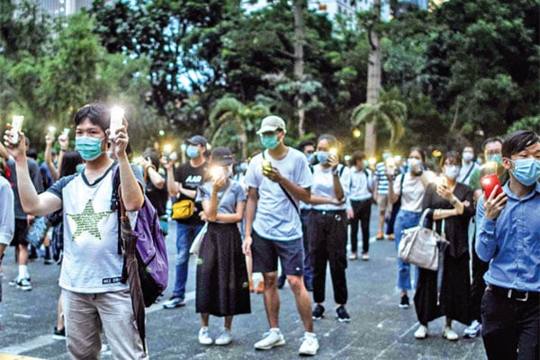 Demonstran menyalakan senter dari gawai mereka pada aksi protes menandai peringatan satu tahun unjuk rasa prodemokrasi 
