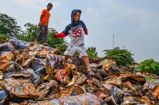 Anak-anak bermain di tumpukan limbah Bahan Beracun dan Berbahaya (B3) di Jakarta, Jumat (27/12/2019).