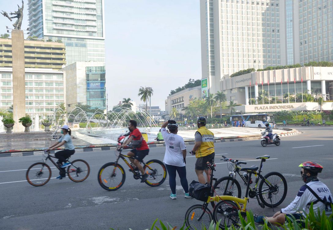 Pengendara sepeda melintasi jalan protokol di Kawasan Bundaran HI, Jakarta, Minggu (17/5)..