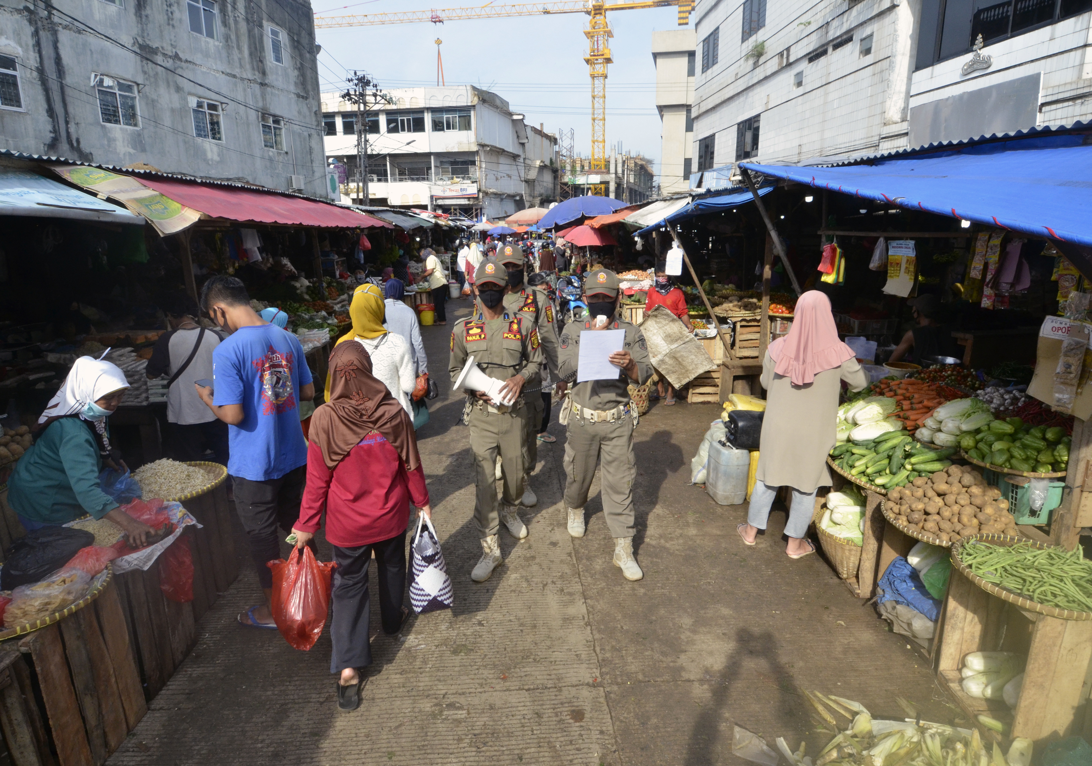 Ilustrasi  petugas melakukan sosialisasi protokol kesehatan di pasar tradisional di tengah pandemi covid-19
