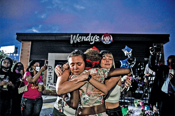 Warga berpelukan dalam aksi protes penembakan Rayshard Brooks oleh polisi di Atlanta, Georgia, AS