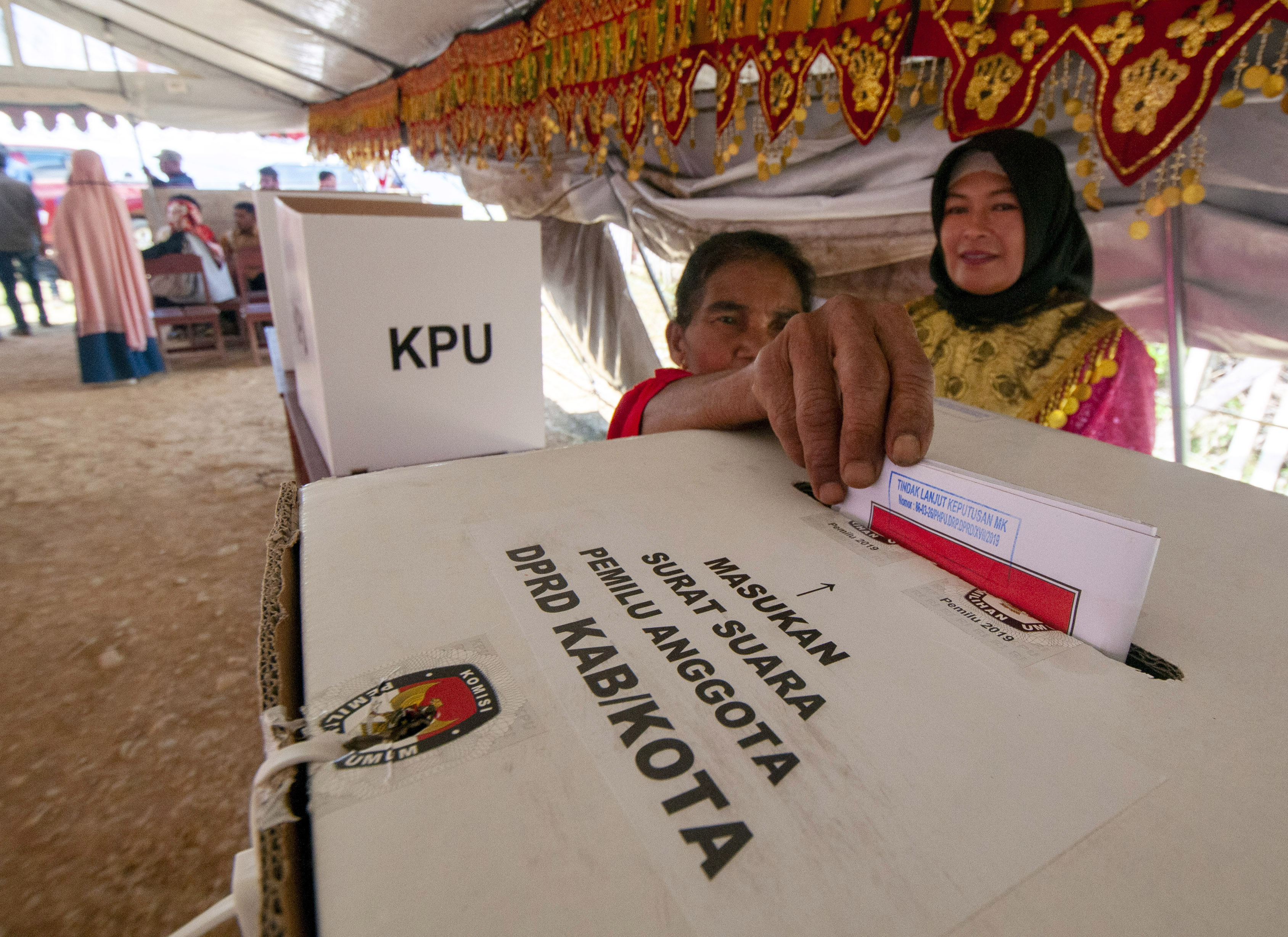 Seorang warga memasukkan surat suara di TPS Desa Bolobia, Sulawesi Tengah.