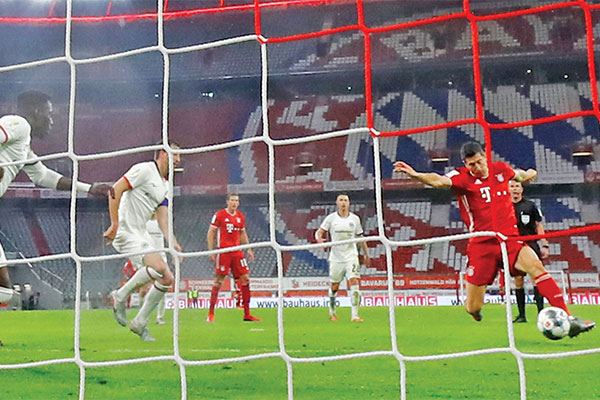 Penyerang Bayern Muenchen asal Polandia, Robert Lewandowski (kanan), melesakkan bola tanpa mampu dibendung bek Eintracht Frankfurt