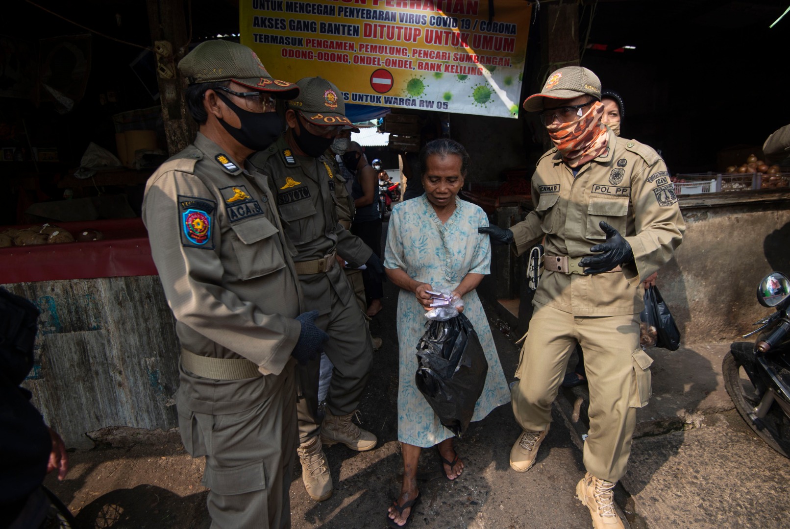 Petugas Satpol PP menindak warga yang  tidak menggunakan masker saat berbelanja di Pasar Jatinegara (11/6/2020)