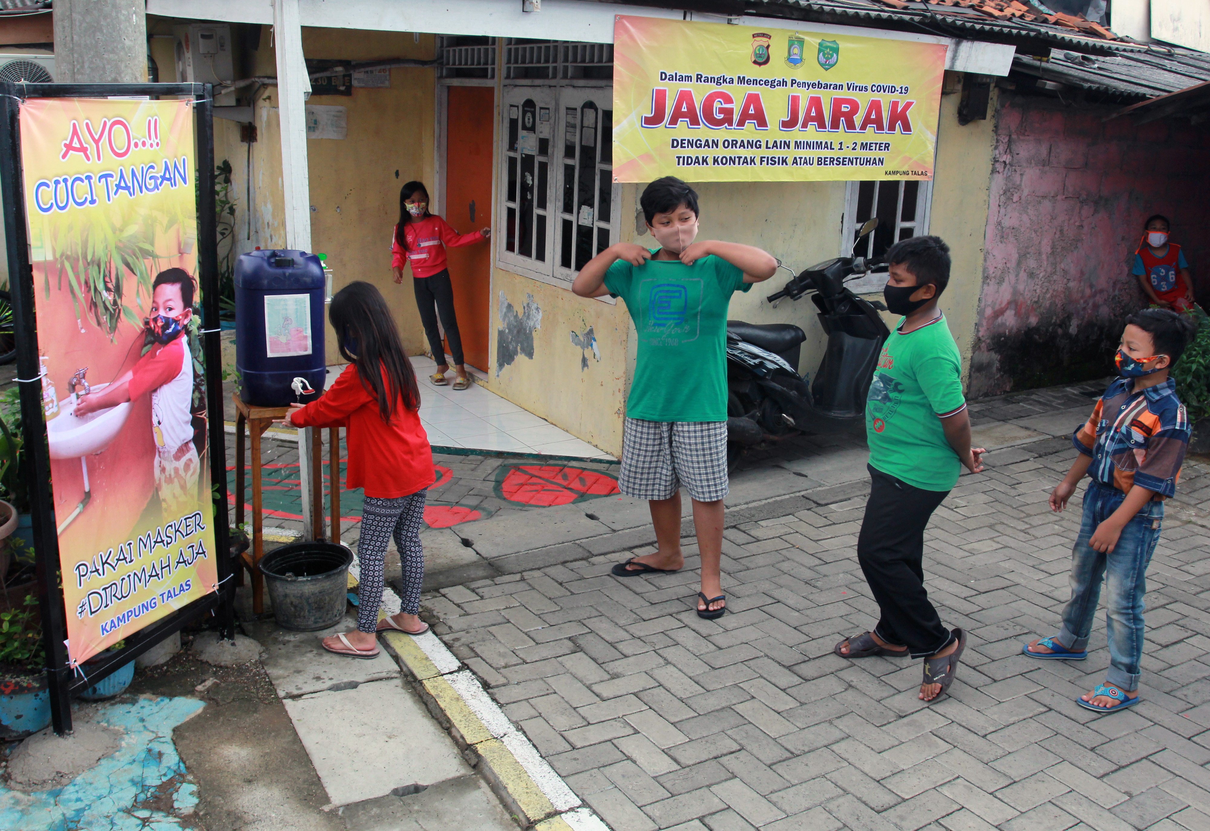  Sejumlah anak dengan mengenakan masker mengantre untuk mencuci tangan usai bermain di Kampung Normal Baru Taman Lalu Lintas, Karawaci