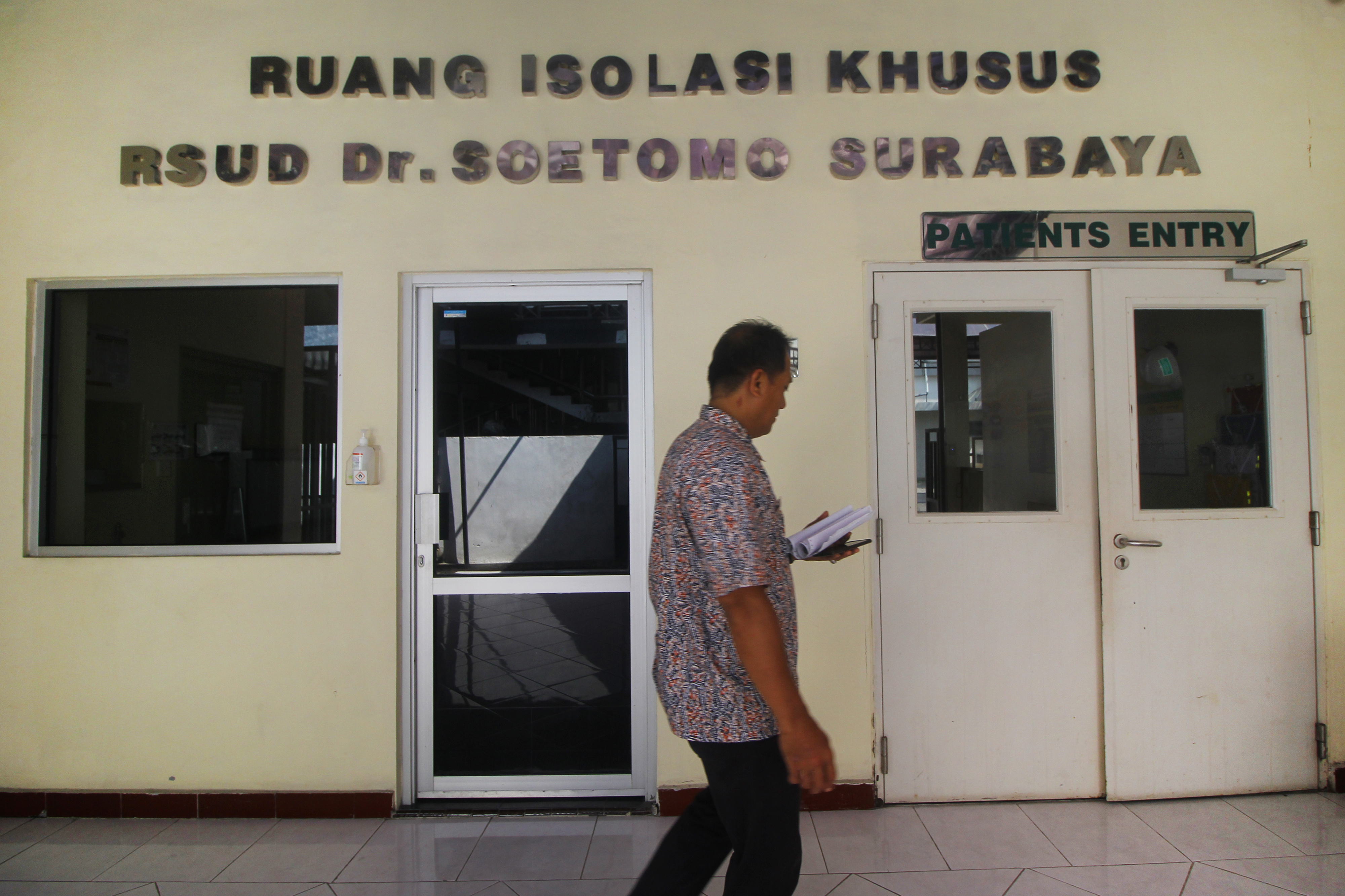 : Petugas melintas di depan pintu masuk Ruang Isolasi Khusus (RIK) RSUD Dokter Soetomo, Surabaya, Jawa Timur. 