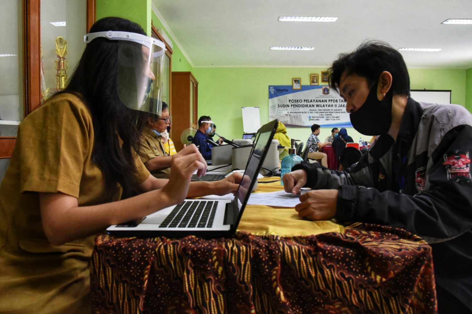 Petugas melayani orangtua calon siswa yang mencari informasi PPDB 2020 di posko PPDB SMA Negeri 70, Jakarta