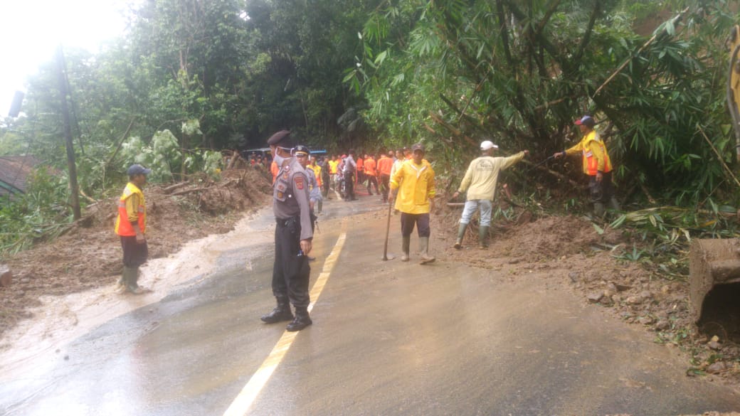 Warga dibantu TNI dan Polri membantu membersihkan longsoran yang menutup akses jalan di Kabupaten Tasikmalaya, Jumat (19/6/2020)