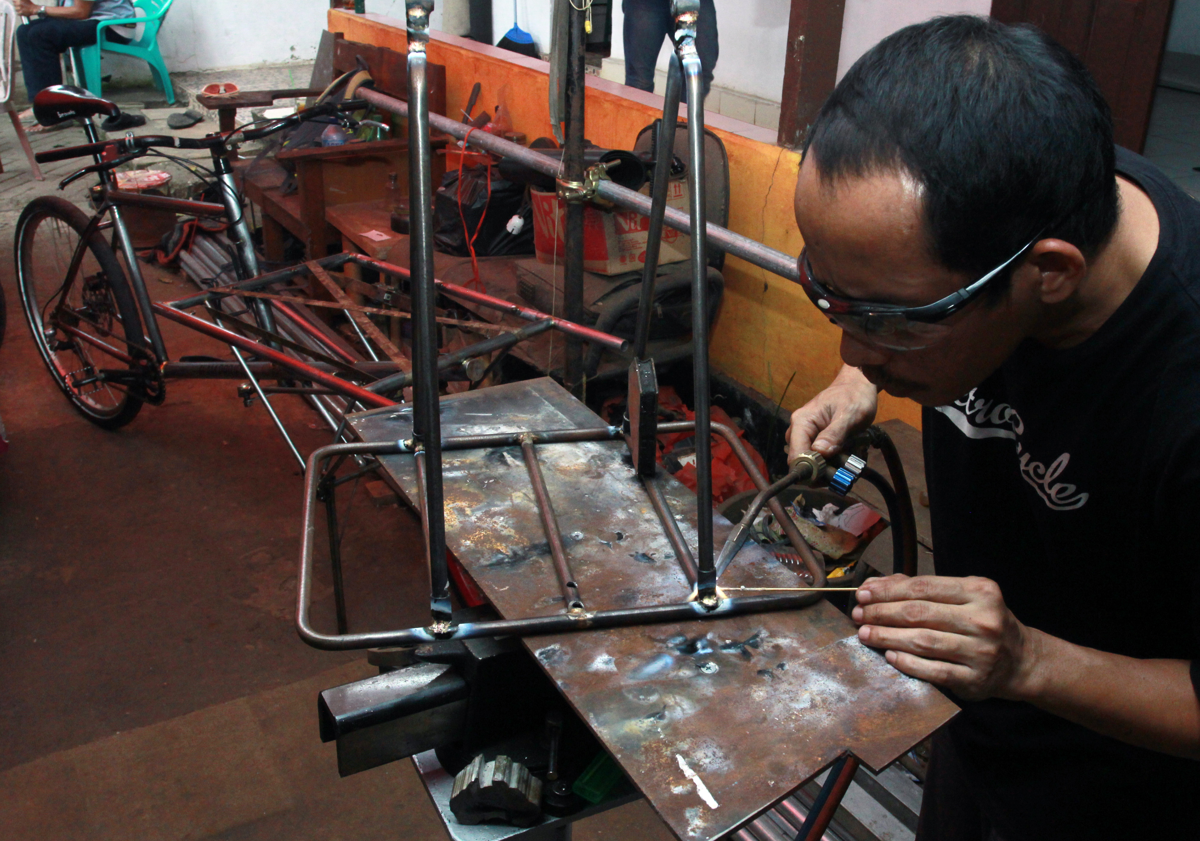 Seorang pembuat sepeda kargo menyelesaikan pesanan pelanggannya di workshop Alam Project di Pamulang, Tangerang Selatan, Senin (22/6).